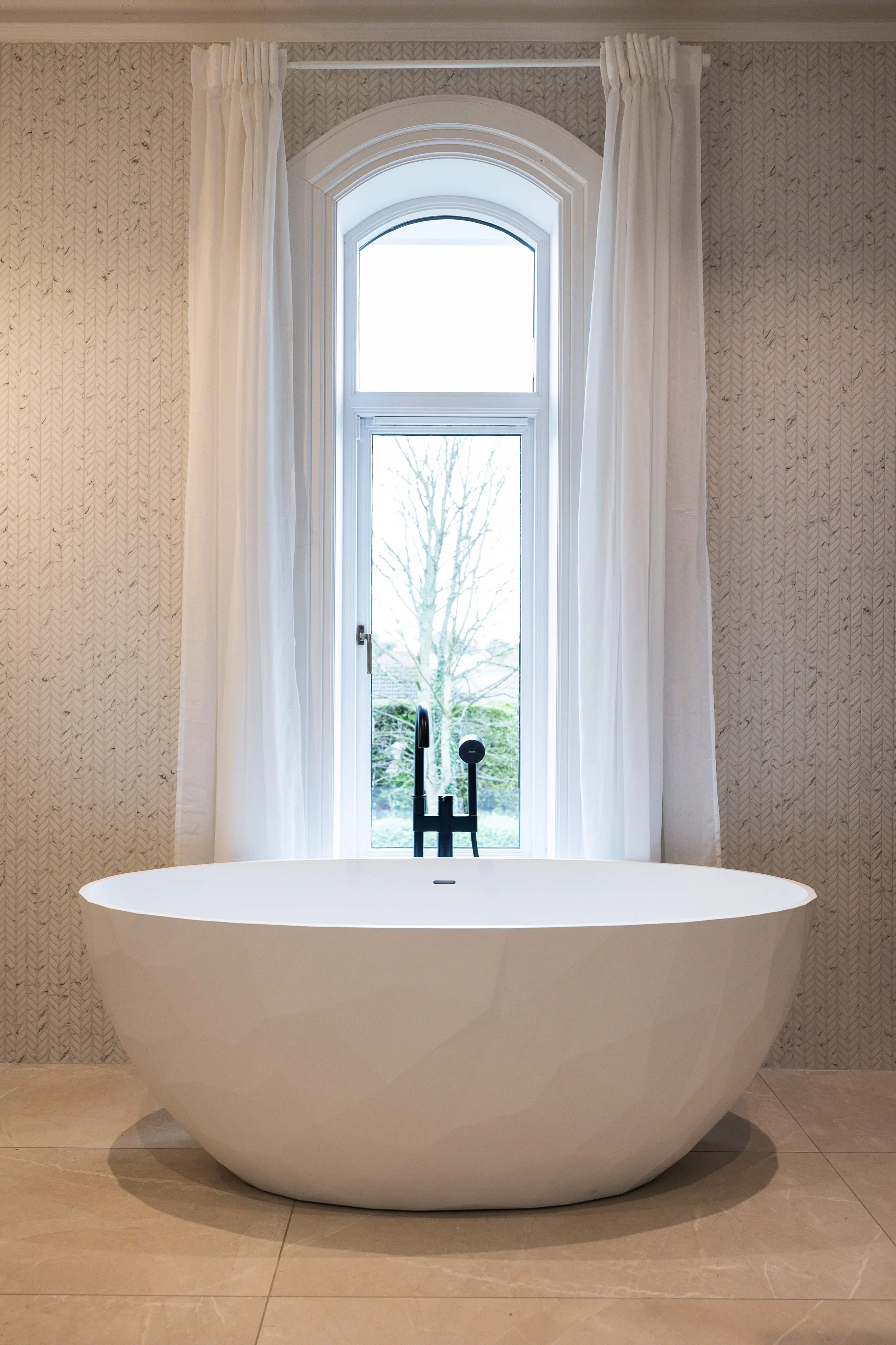 Luxury bathroom with freestanding bath beside large window