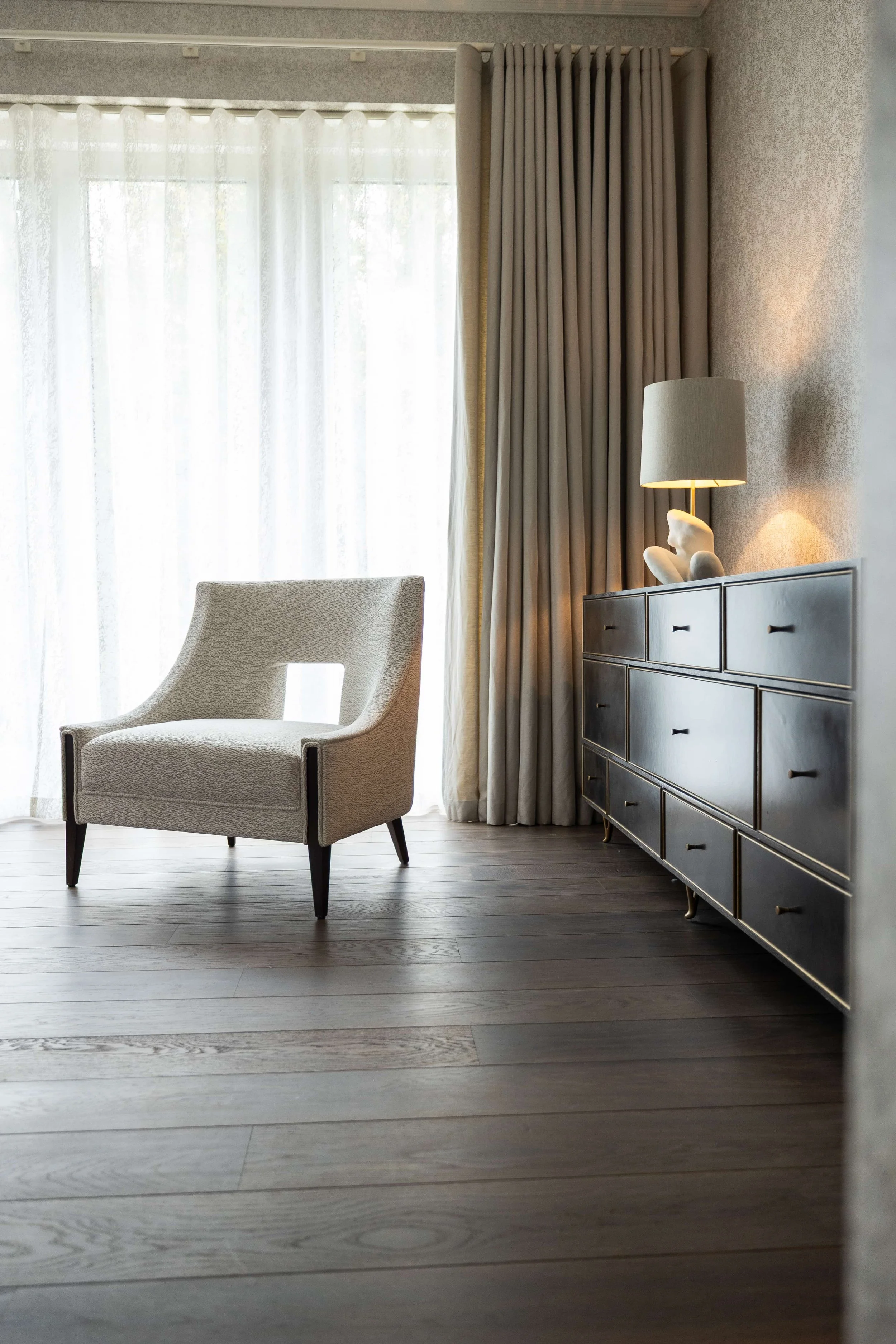 Completed luxury living area with bespoke cabinetry, layered lighting and full-height curtains.