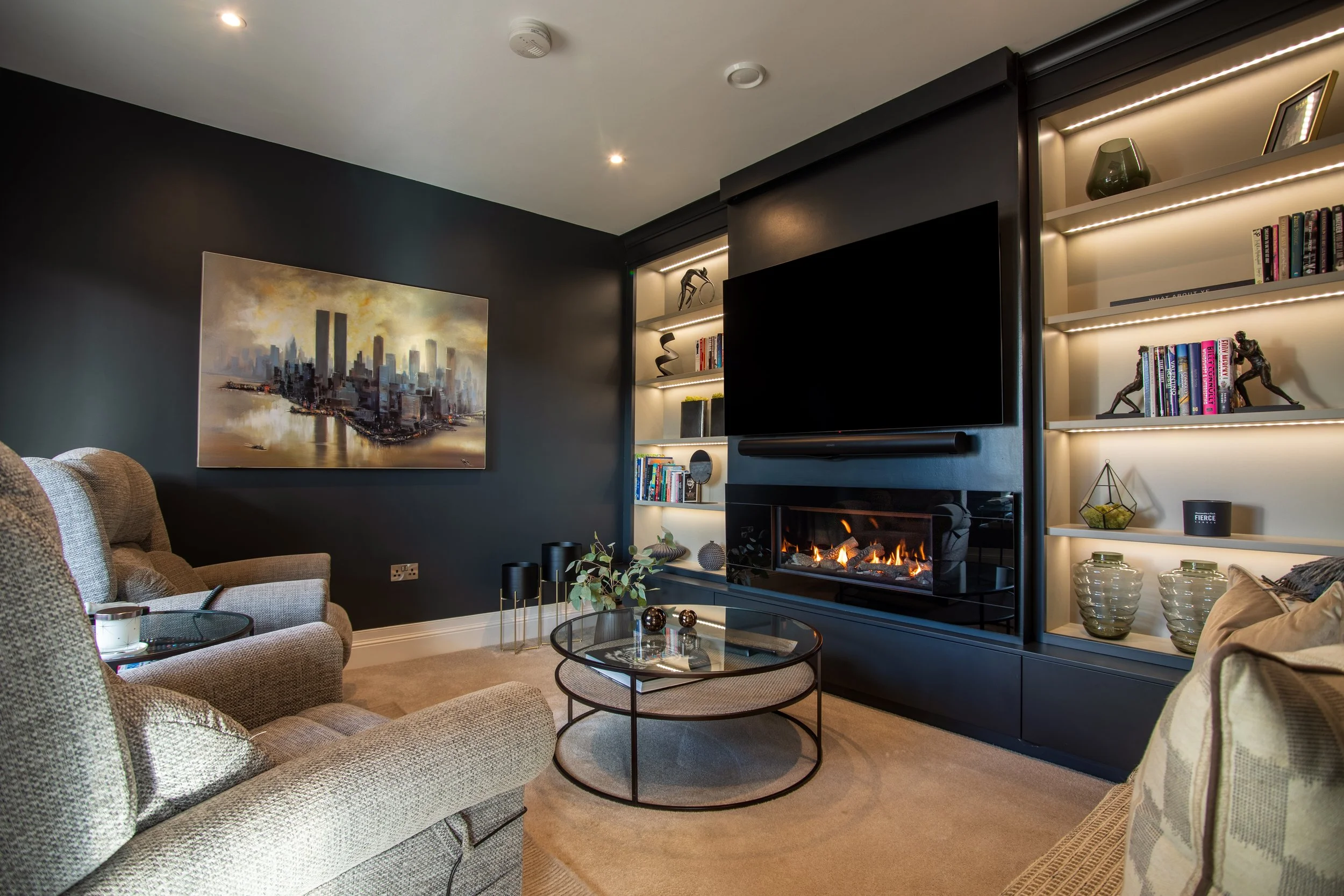 Completed living room with dark media wall, fireplace and integrated shelving.
