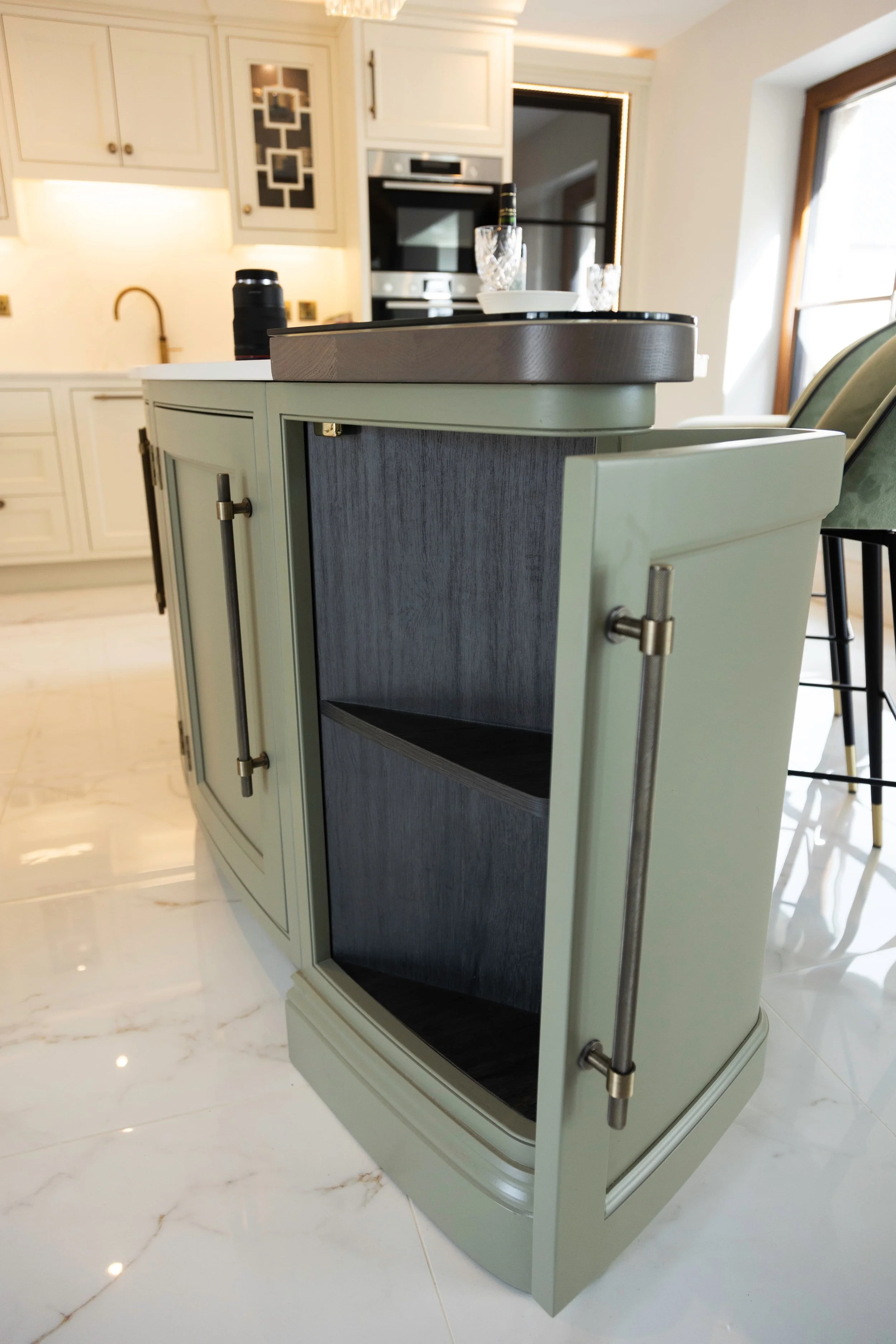 Bespoke curved kitchen island with painted cabinetry, contrasting worktop and integrated storage by Darren Morgan Design.