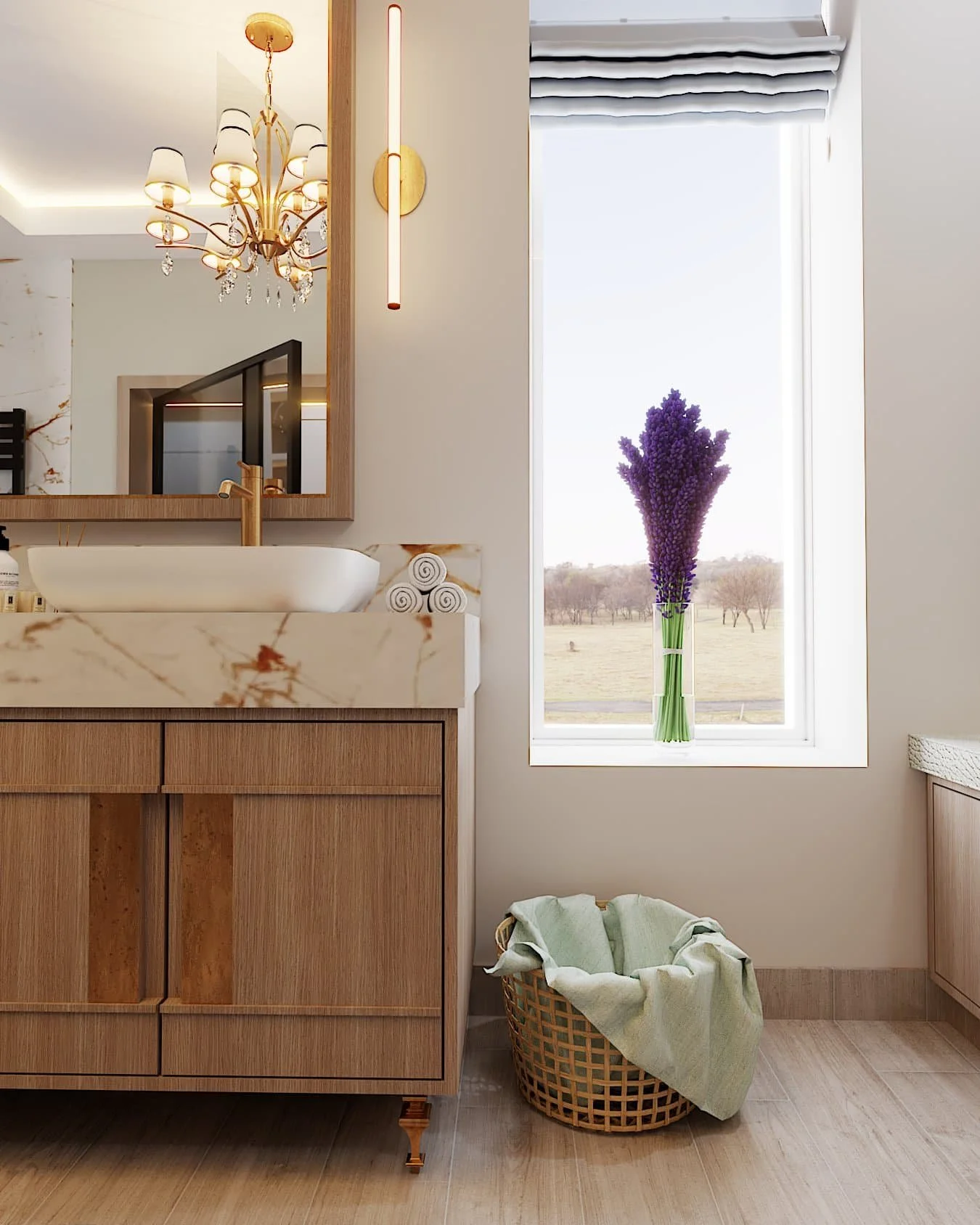 a modern bathroom with light neutral wooden floor and cabinet, marbel countertop and white sink with gold faucets, lighting and accents. A long window with lavender in a vase lets light in and a laundry basket is below it on the floor
