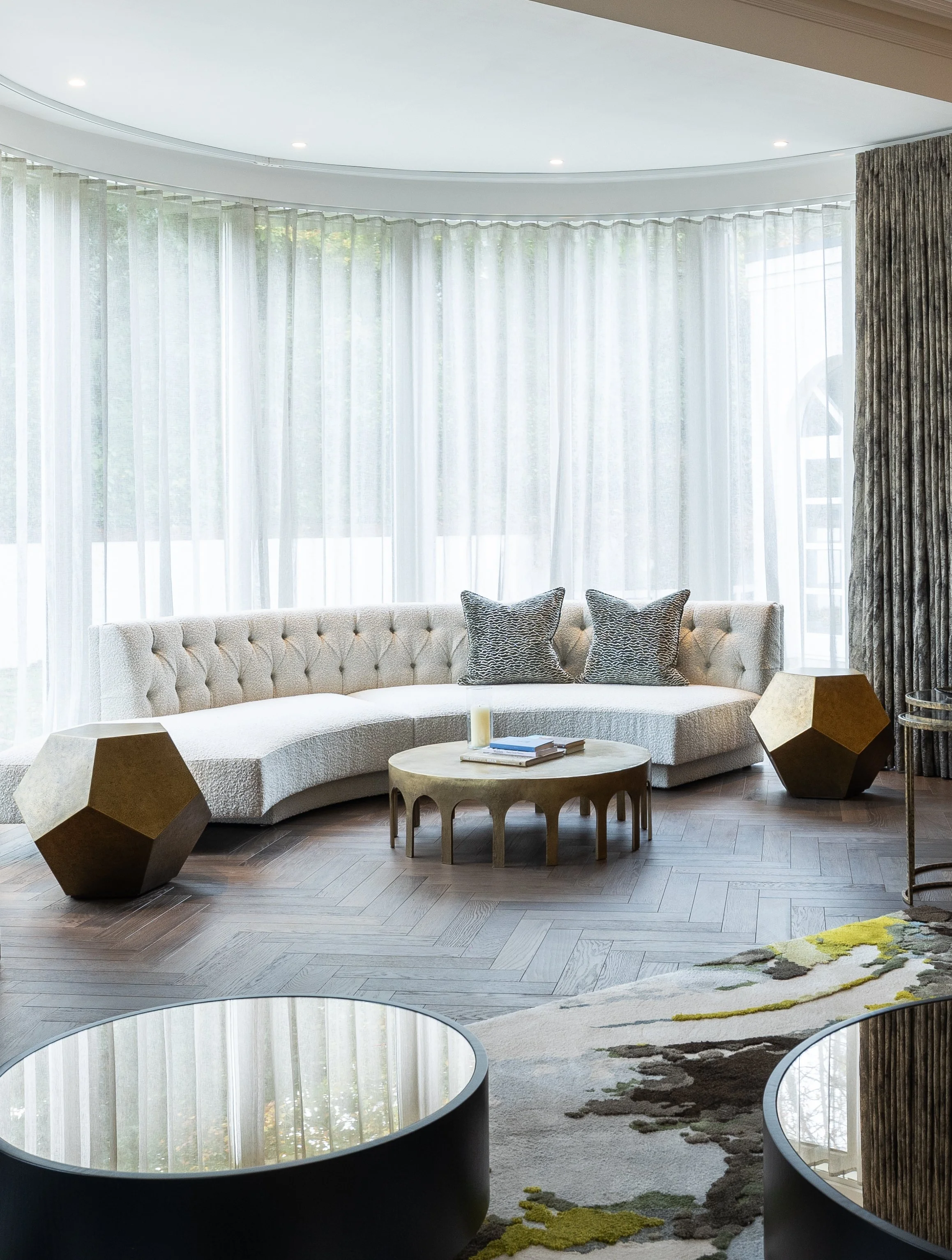 Completed living room with curved sofa, bay windows and bespoke furniture.