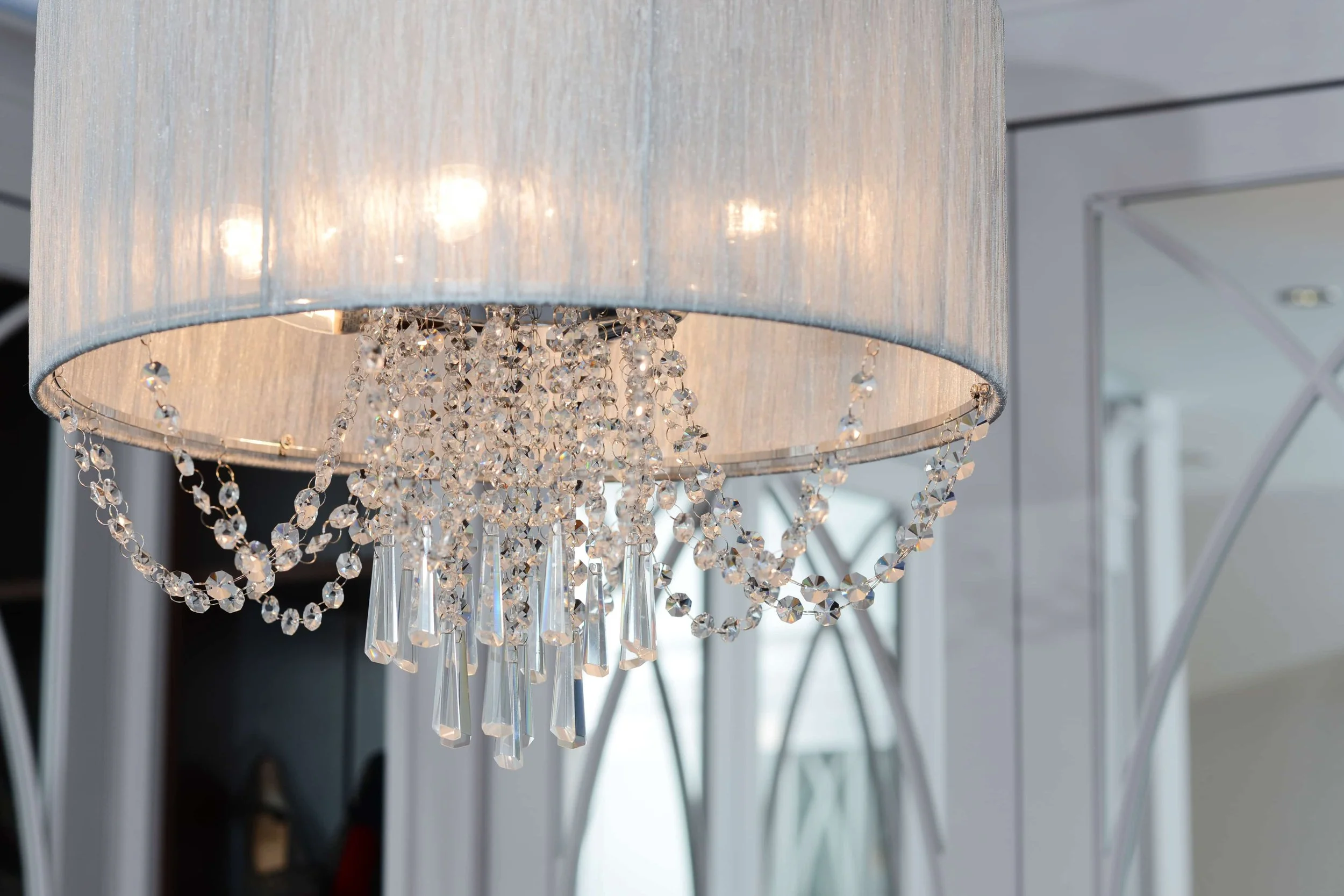 Close detail of a crystal pendant light within a completed home interior.