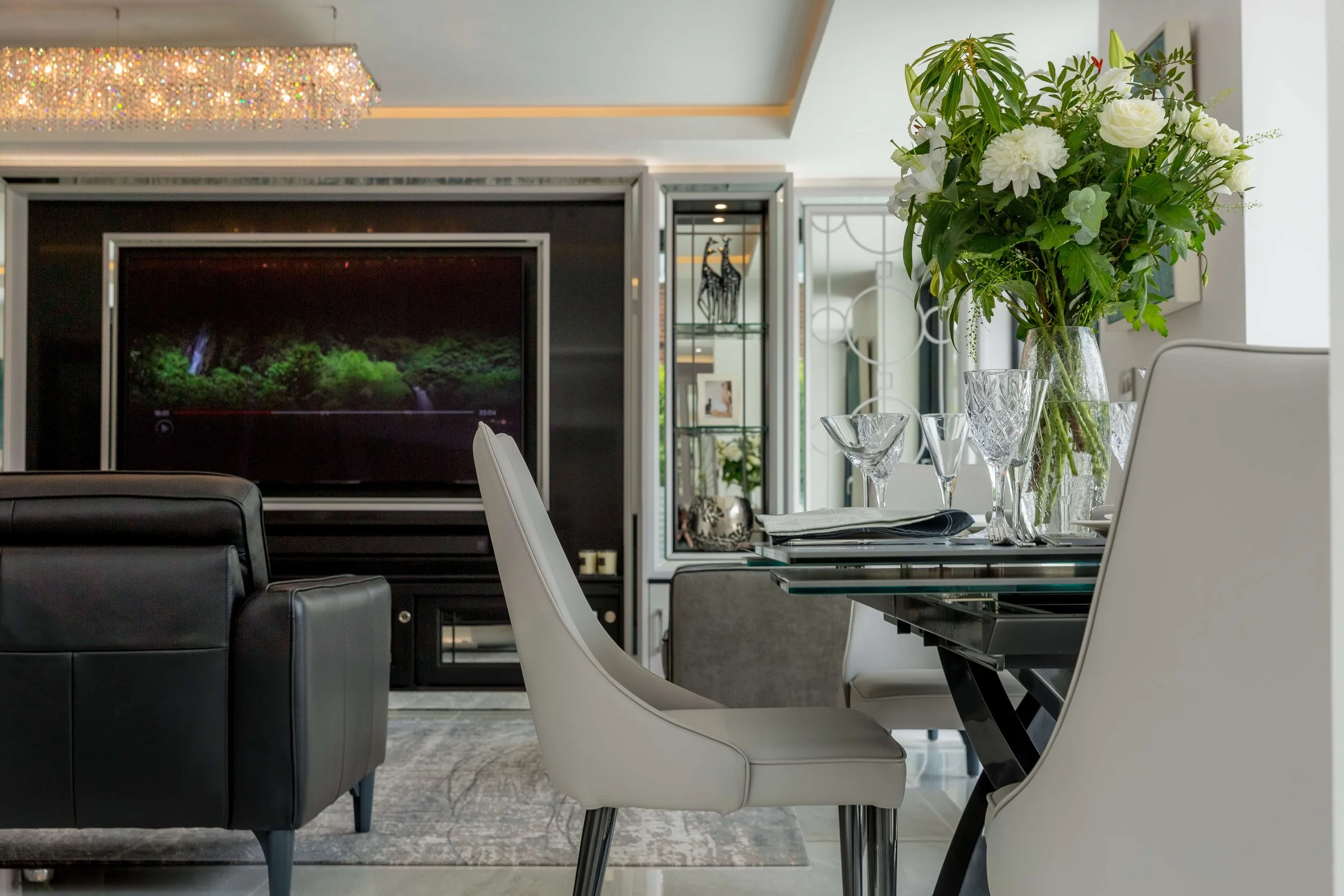 Completed dining and living area with bespoke cabinetry, fireplace and mirrored detailing.