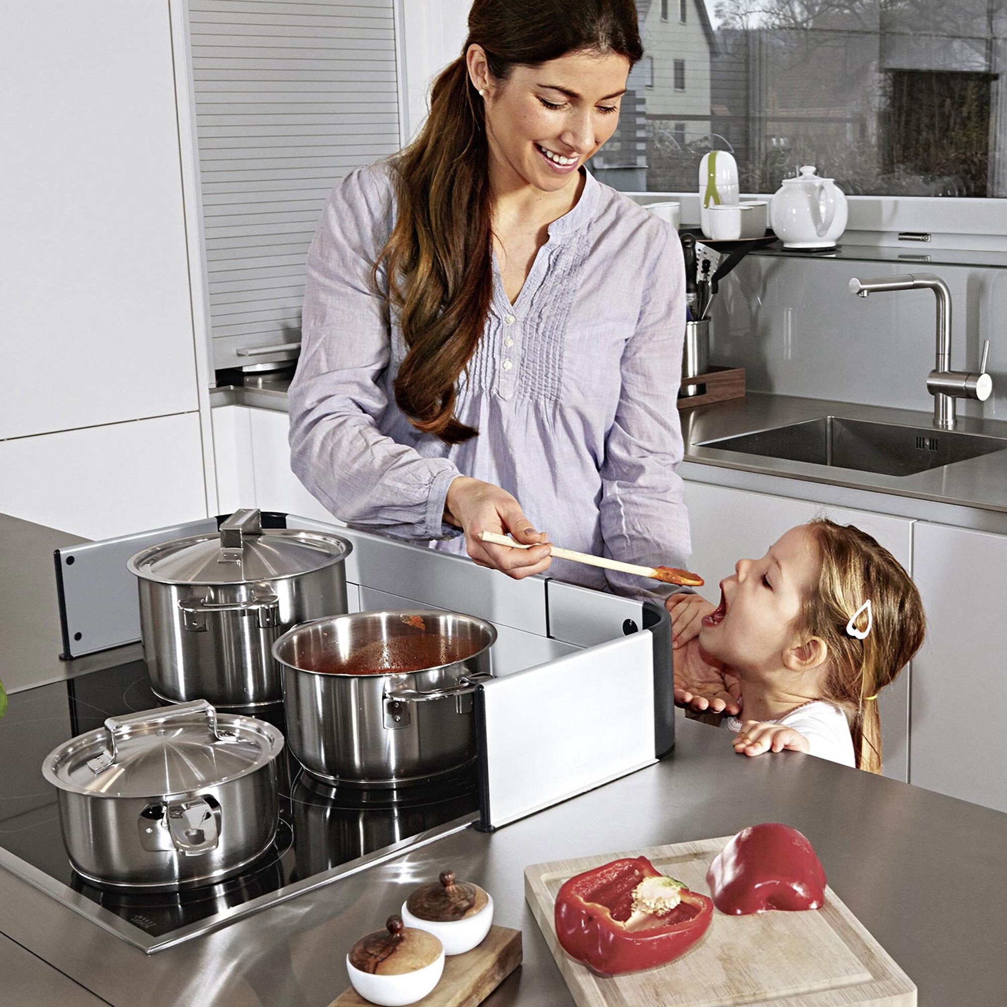 Child being protected by the Adhesive Stove Guard while tasting food