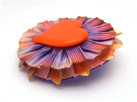 side view of vintage heart pin made into rosette brooch with ribbon cockade