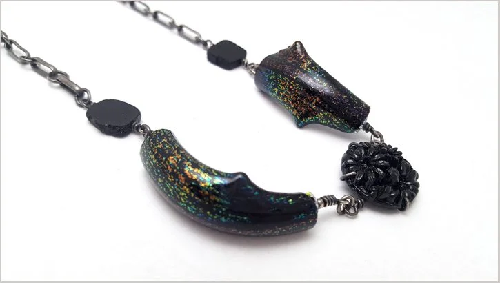 oxidized silver necklace with black tourmaline beads and curved handblown dichroic glass with glass button center