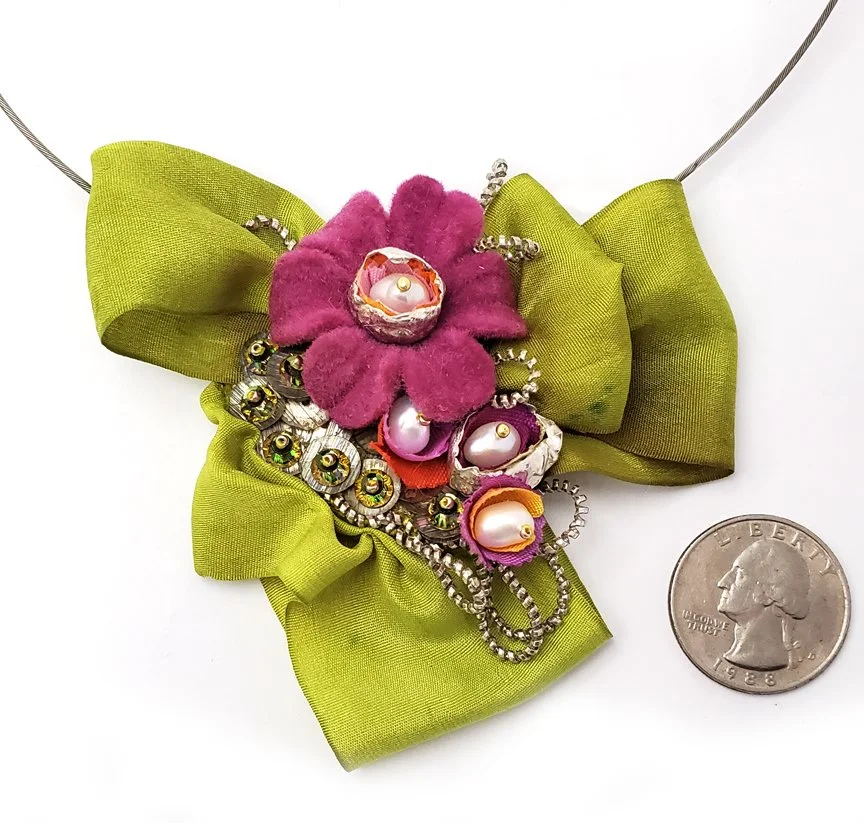 silver necklace with green silk bow center embellished with vintage flower bead, pearls and precious metal clay pods and silver cannetile wire