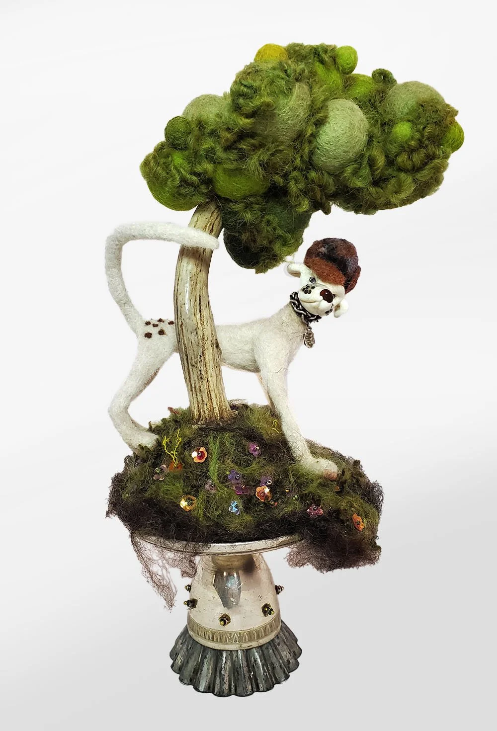 needlefelted sculpture of dog with lampworked glass head under a tree with a trunk made from deer antler