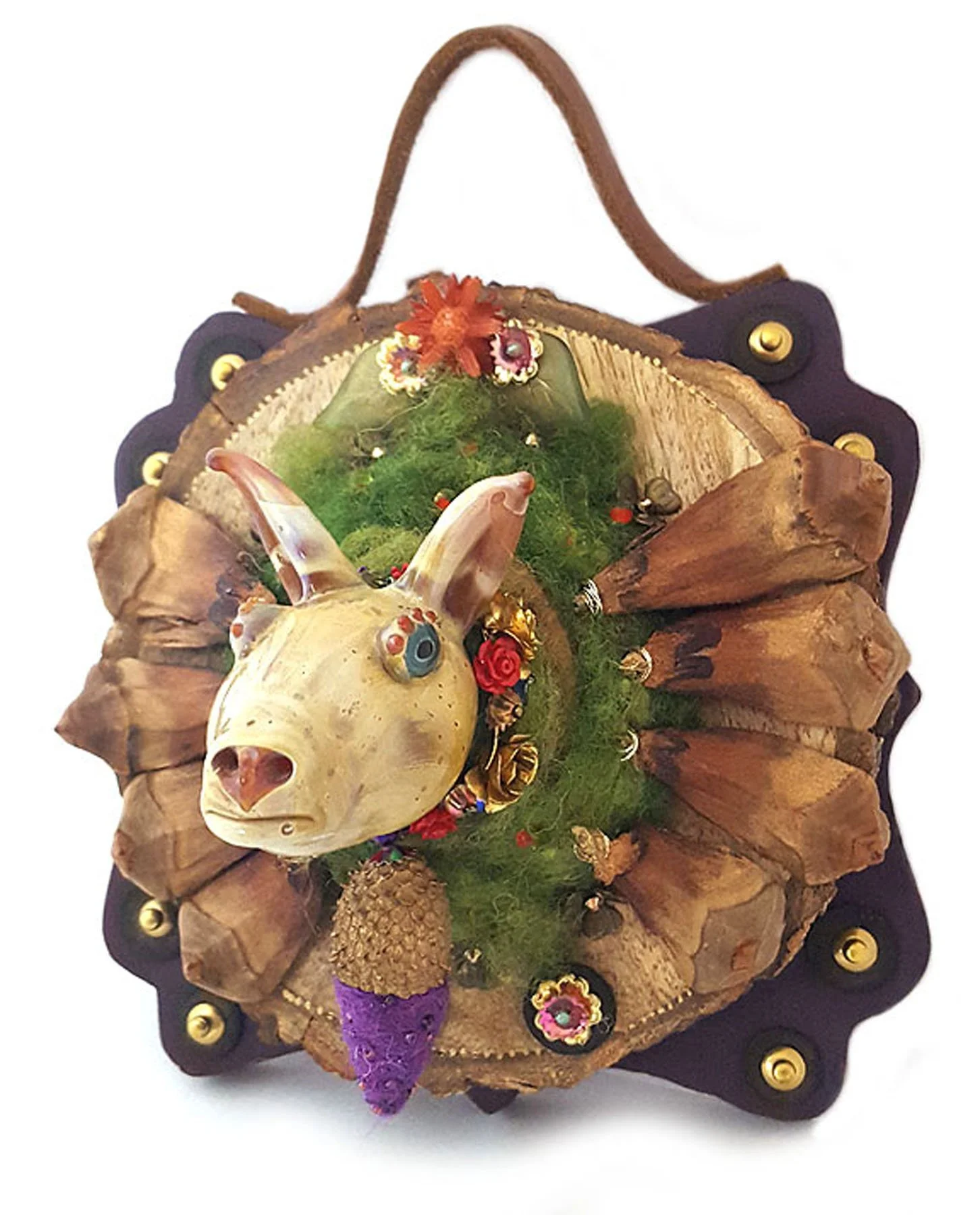 wall plaque of lampworked glass armadillo head decorated with pinecone and wood