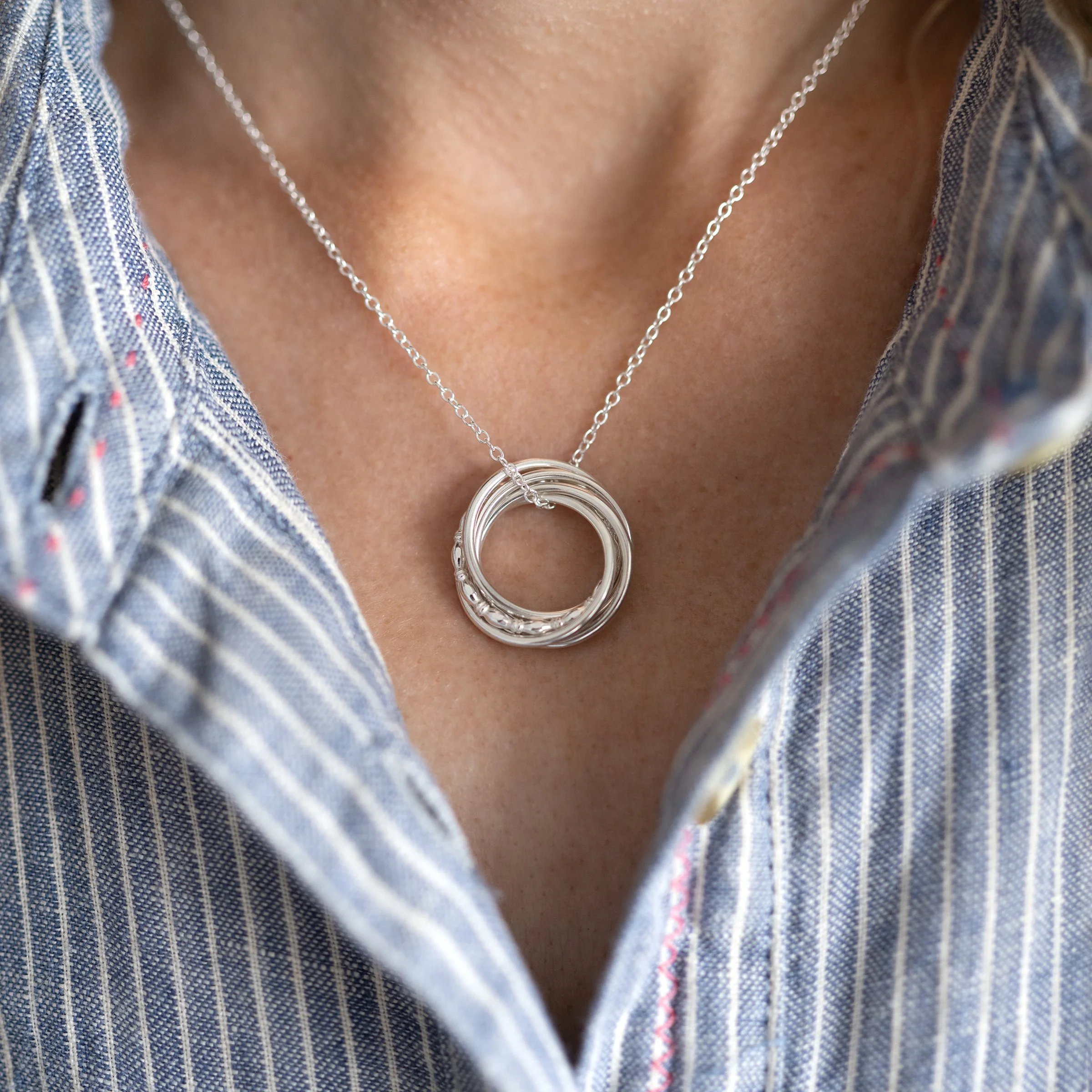 A close up of a person wearing a sterling silver 50th birthday necklace.