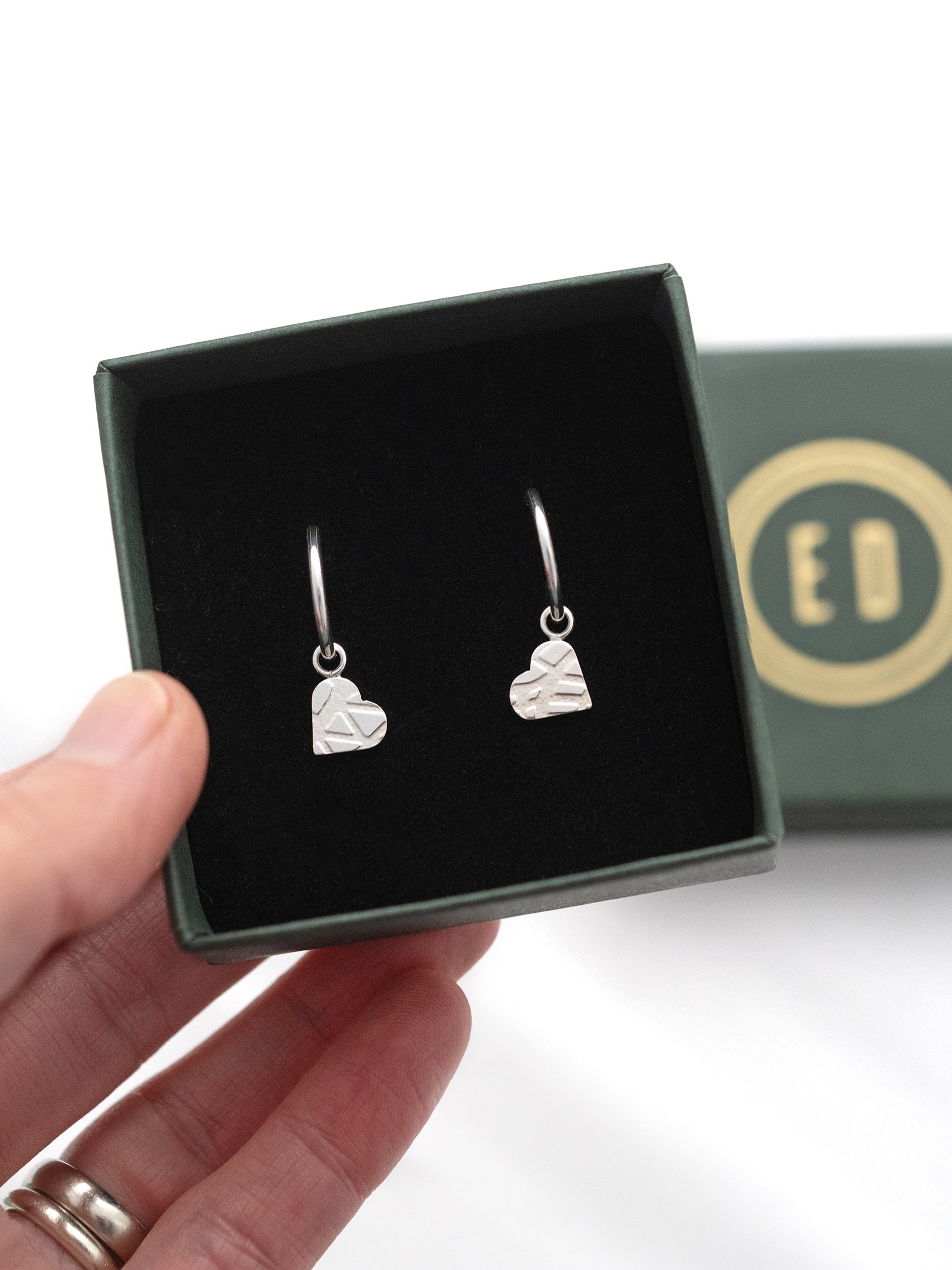 Sterling silver textured heart earrings displayed in an Elizabeth Designs jewellery presentation box.