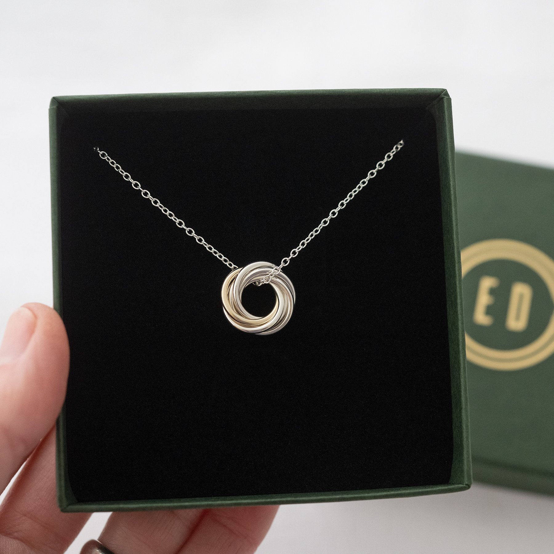 A gold and silver 60th birthday necklace displayed in the presentation box.