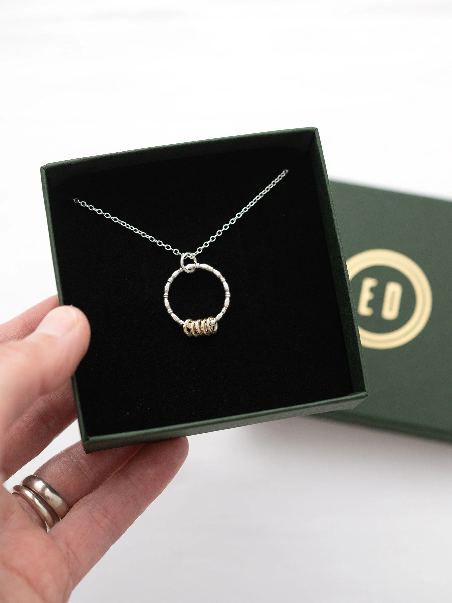 A hallmarked gold and silver 50th necklace displayed in a jewellery presentation box.