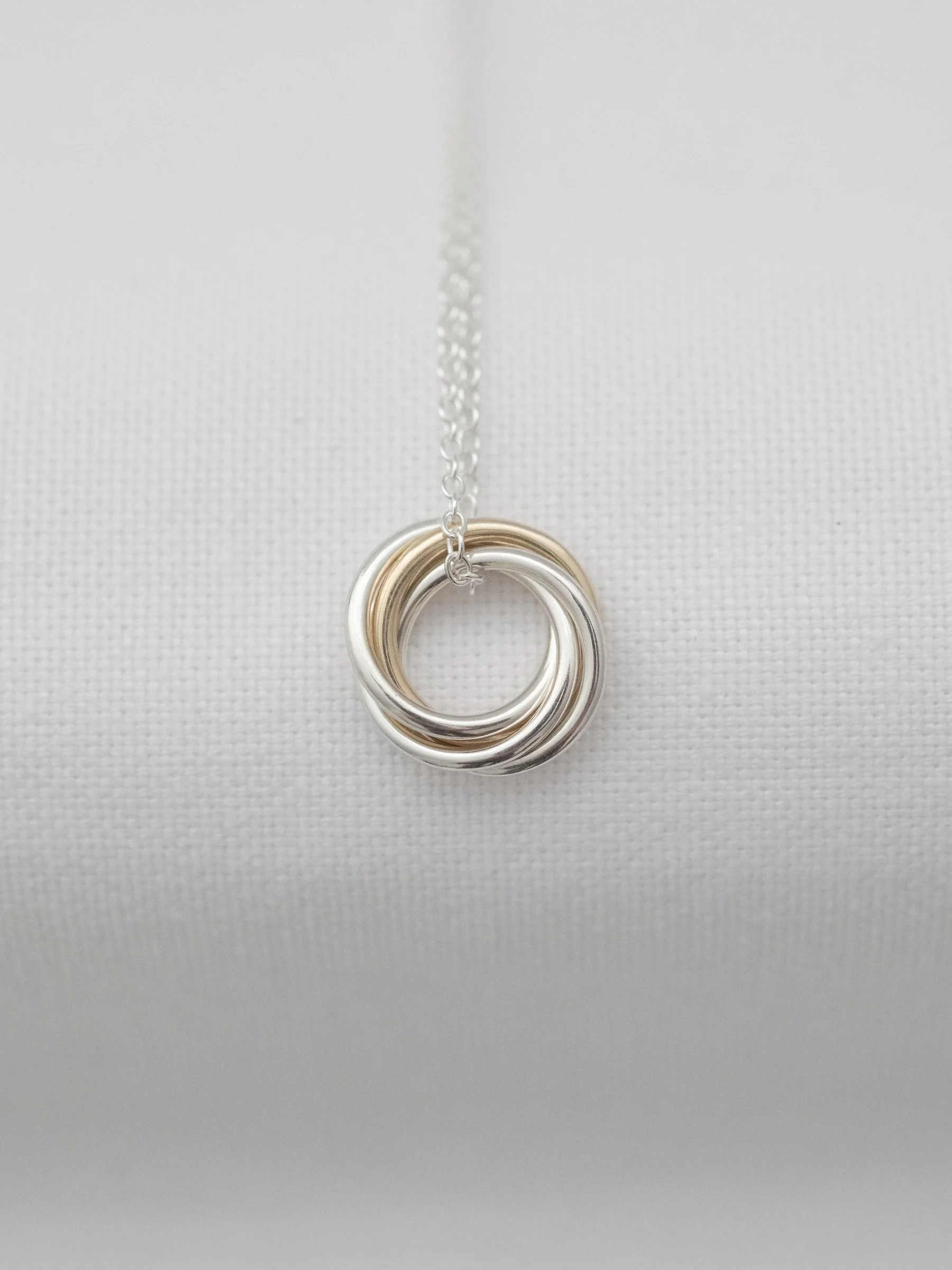 A luxury 40th gold and silver birthday necklace displayed over white material.