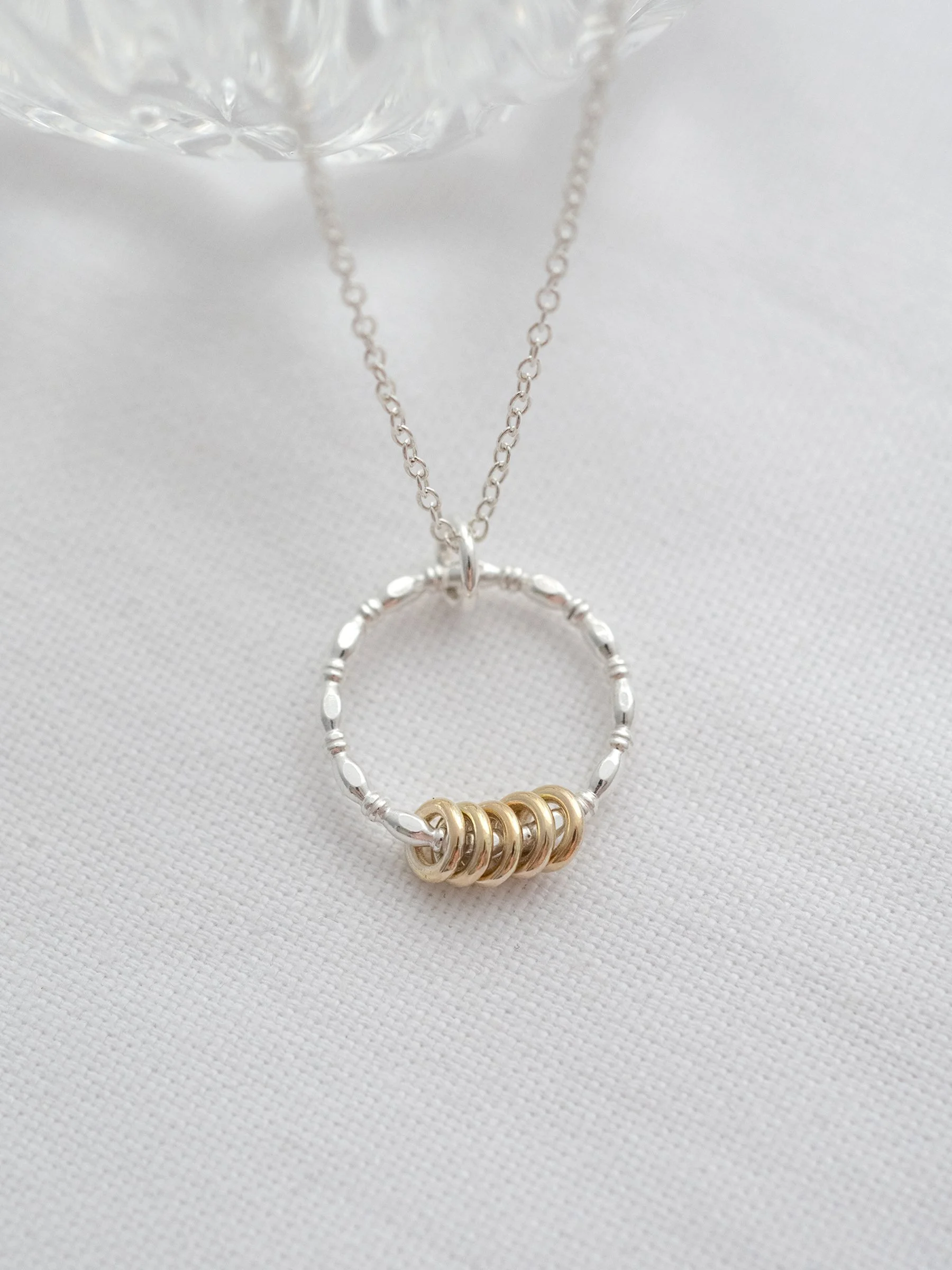 A 50th birthday necklace displayed on white material.
