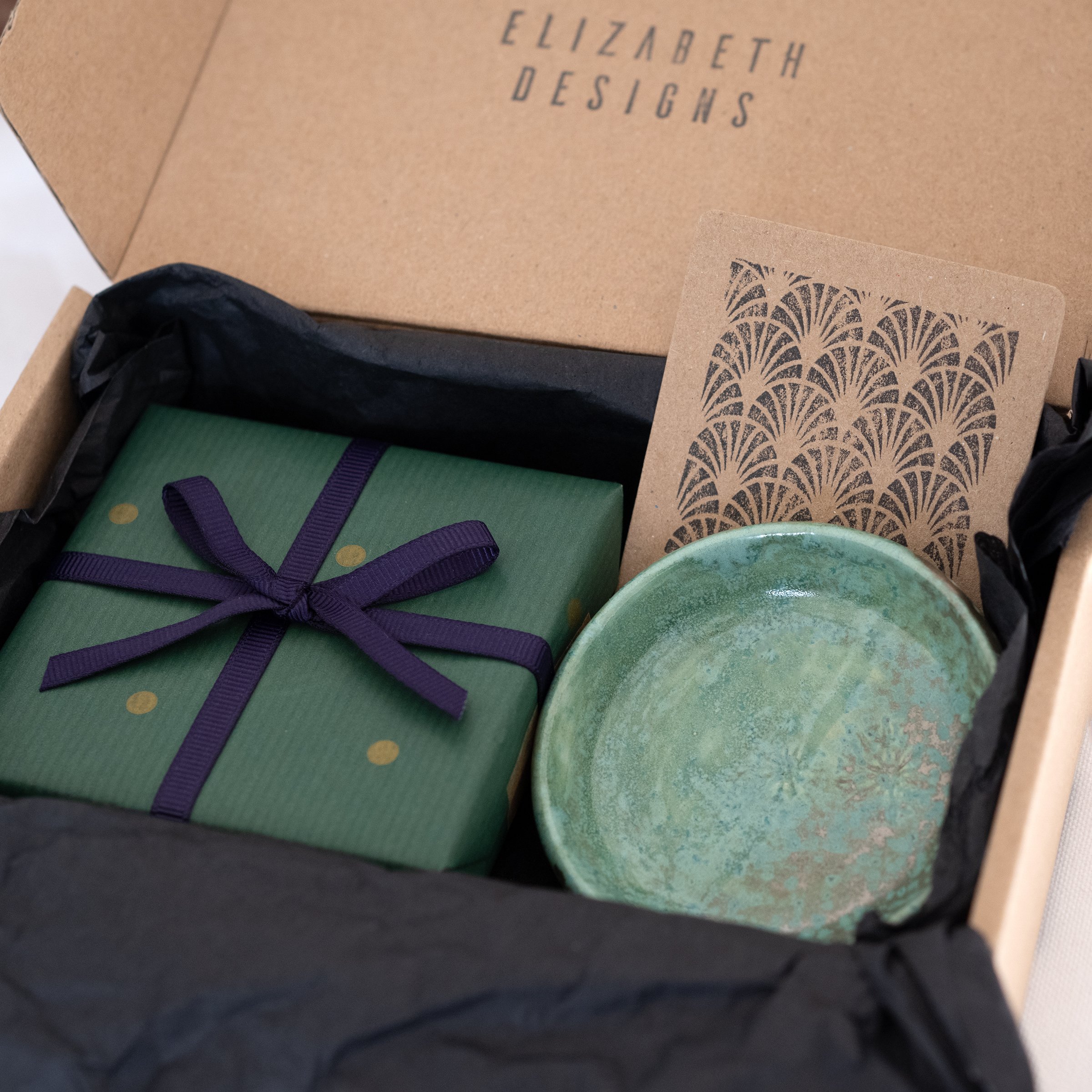 A display of jewellery packing including a green jewellery dish.