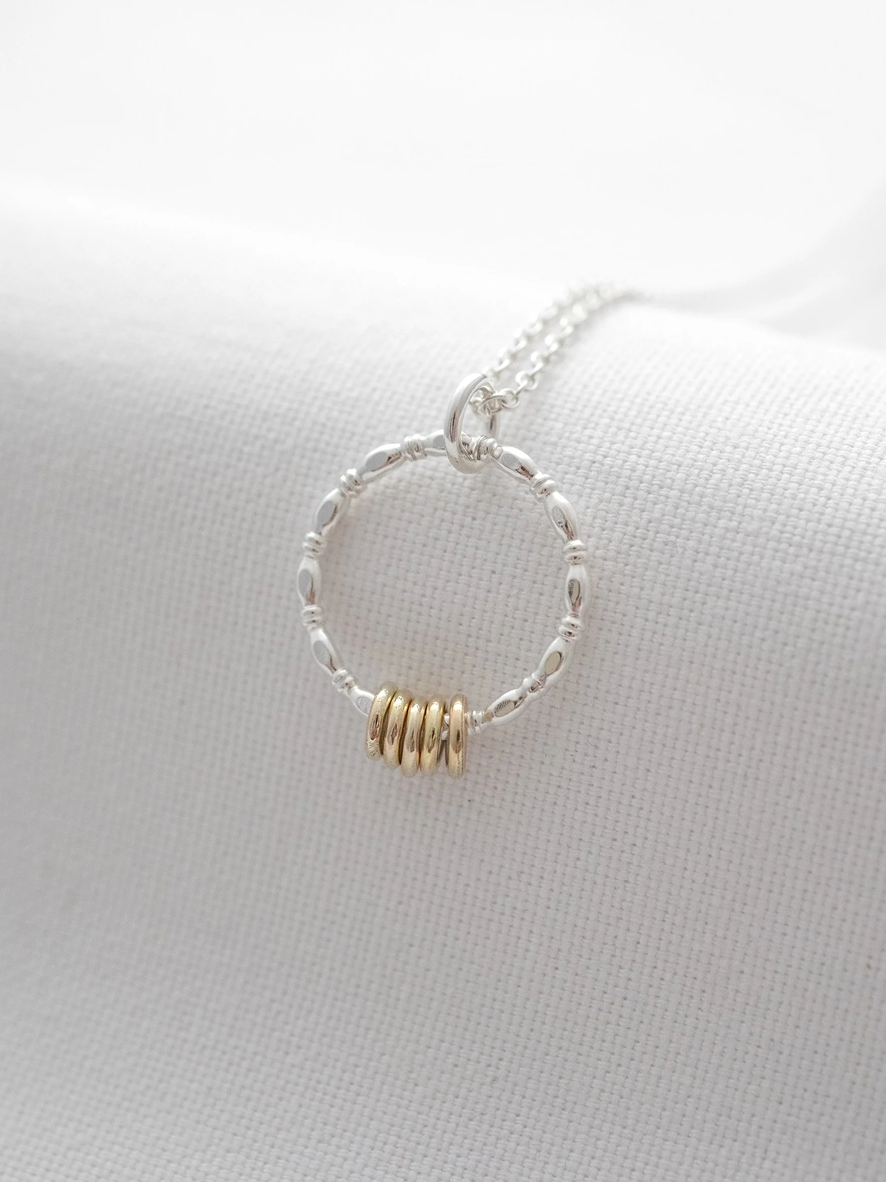 A unique 50th birthday necklace displayed over white material.