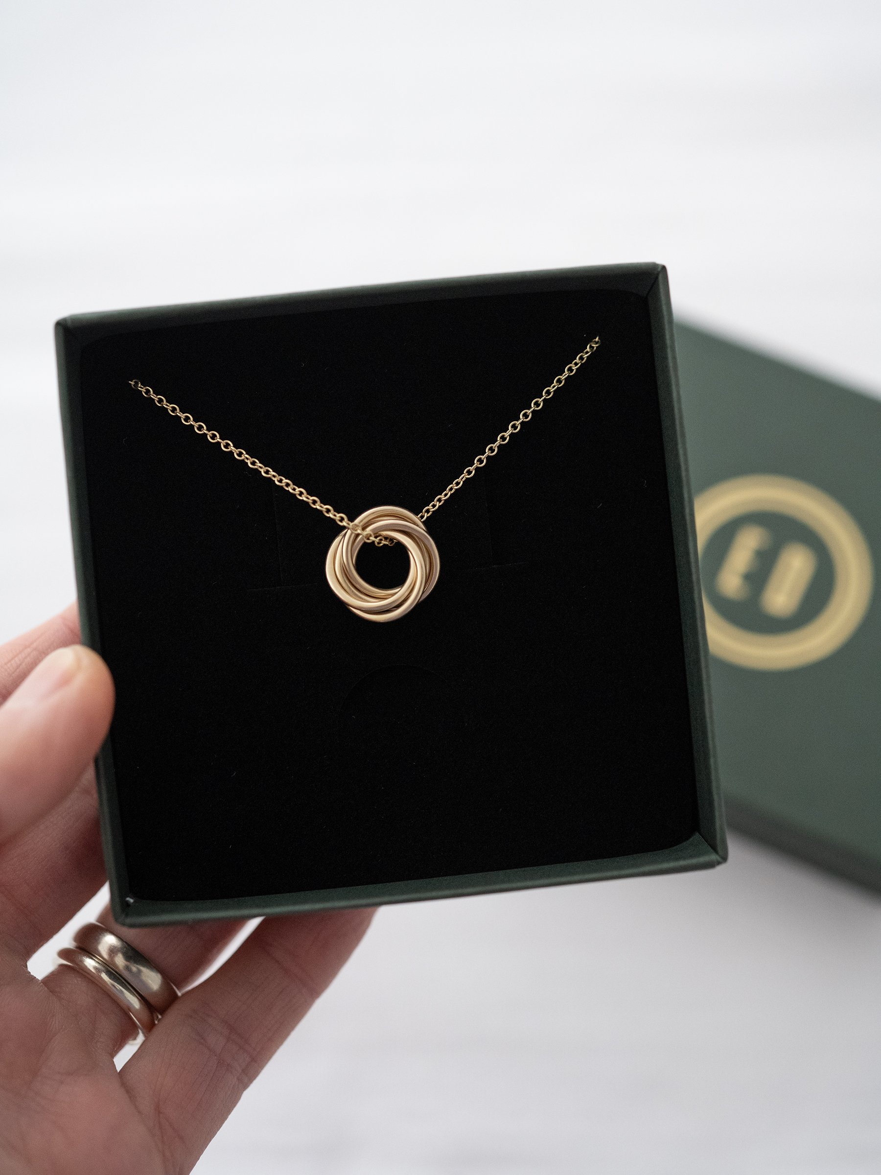 A gold 50th birthday necklace displayed in a presentation box.