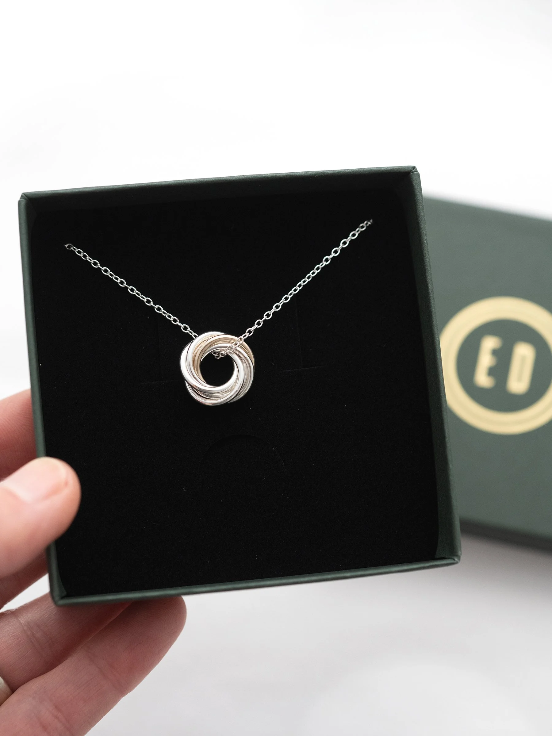 A gold and silver 60th birthday necklace displayed in the presentation box.