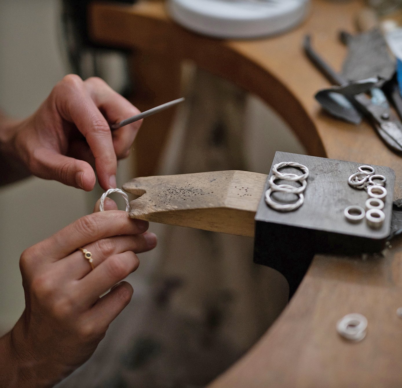 A close up of a jeweller at their bench making a 21st birthday necklace.