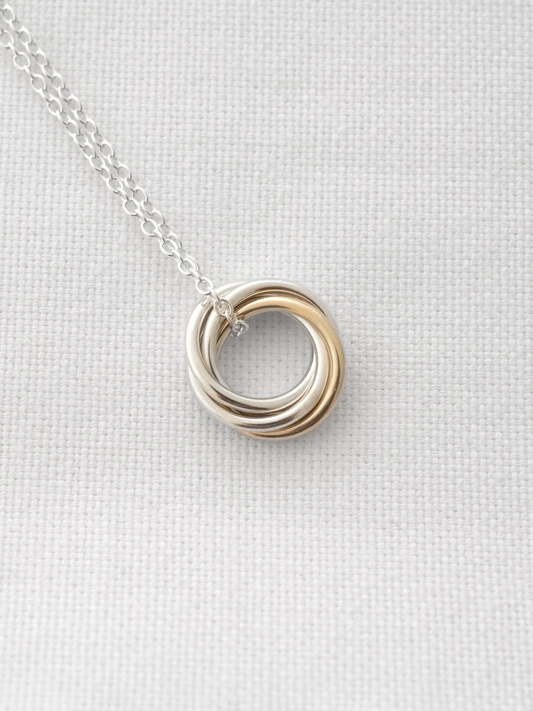 A close up of a handmade 40th necklace displayed on white material.