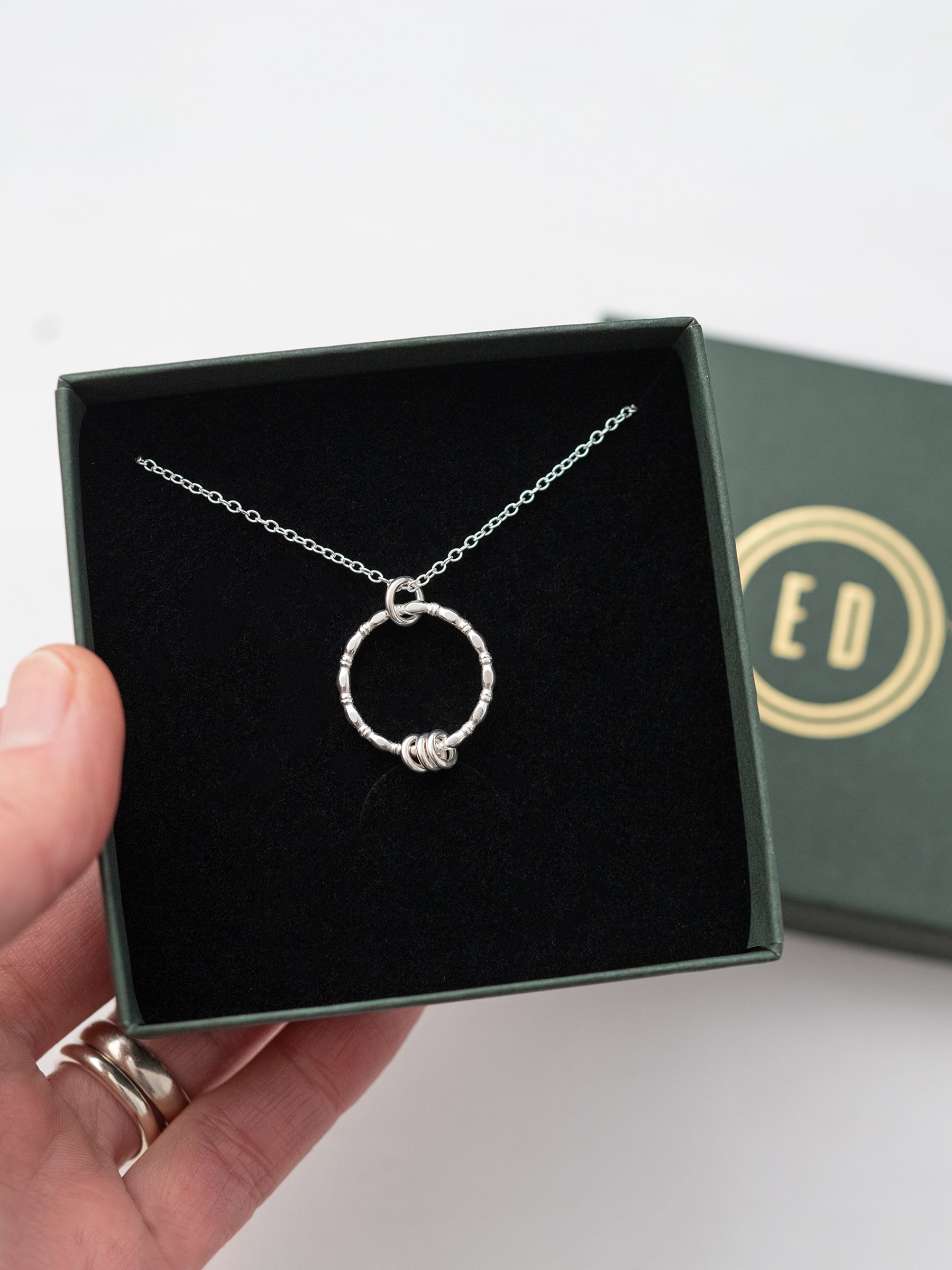 A silver 30th birthday necklace displayed in the presentation box.