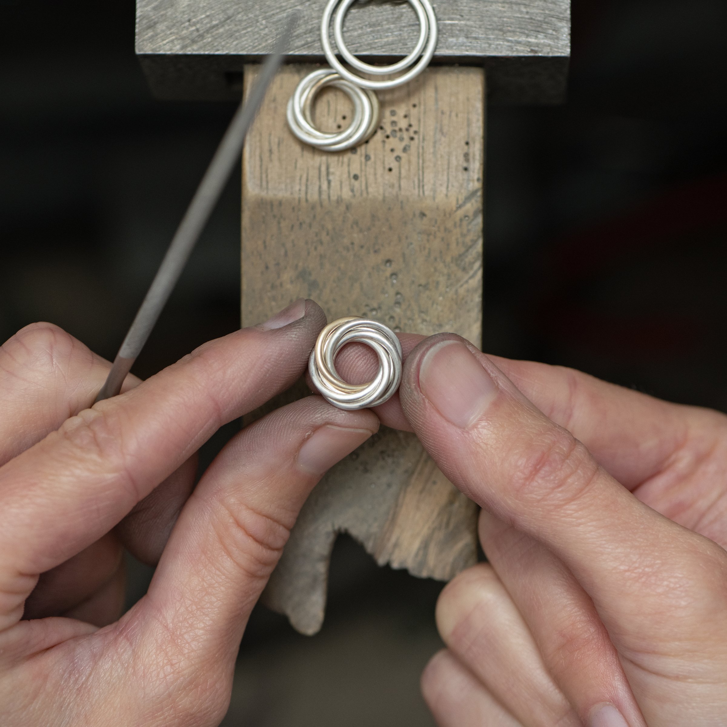 A close up of a jeweller making a 60th birthday necklace.