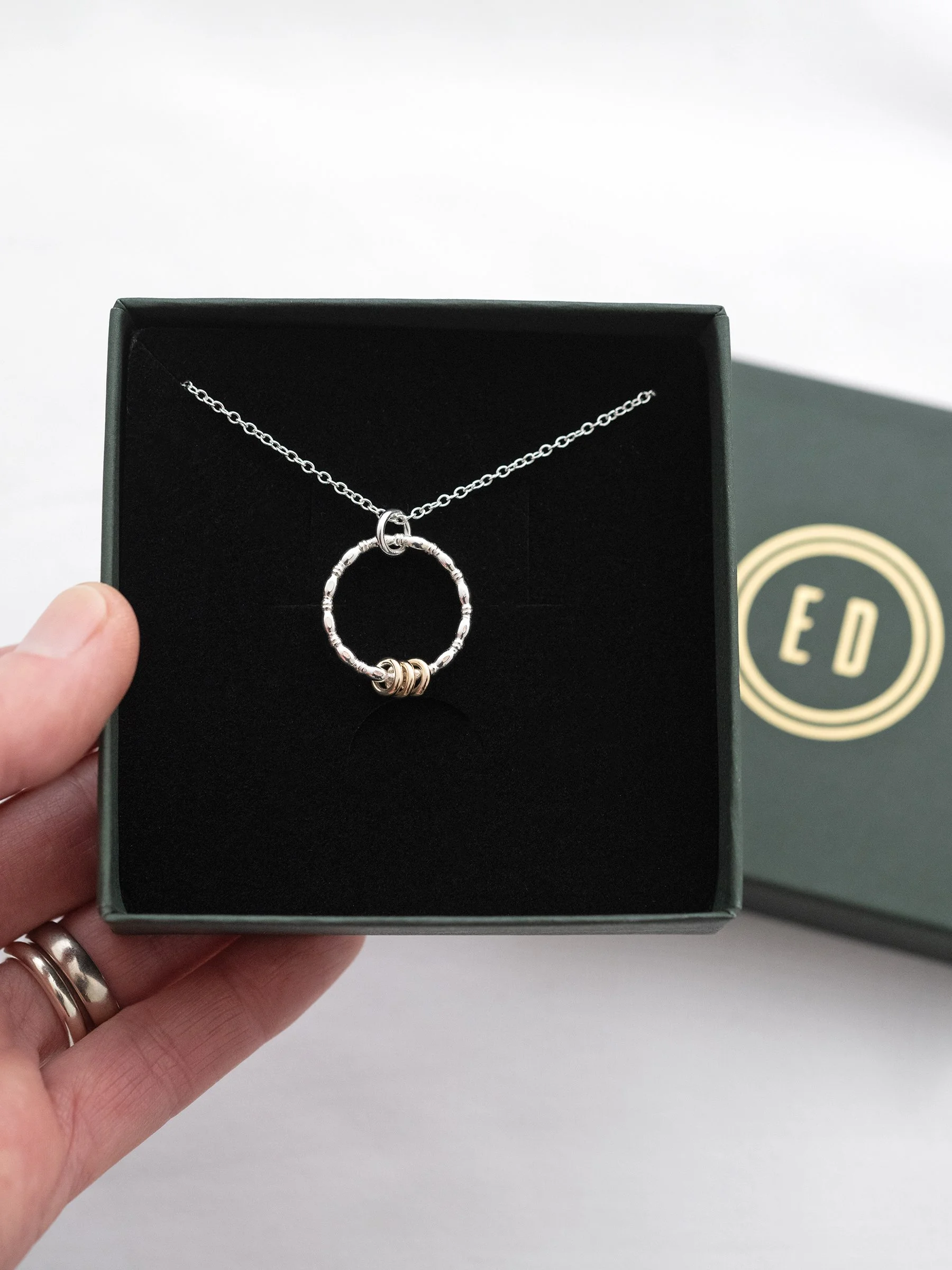 A 30th gold and silver birthday ring necklace displayed in an Elizabeth designs jewellery box.