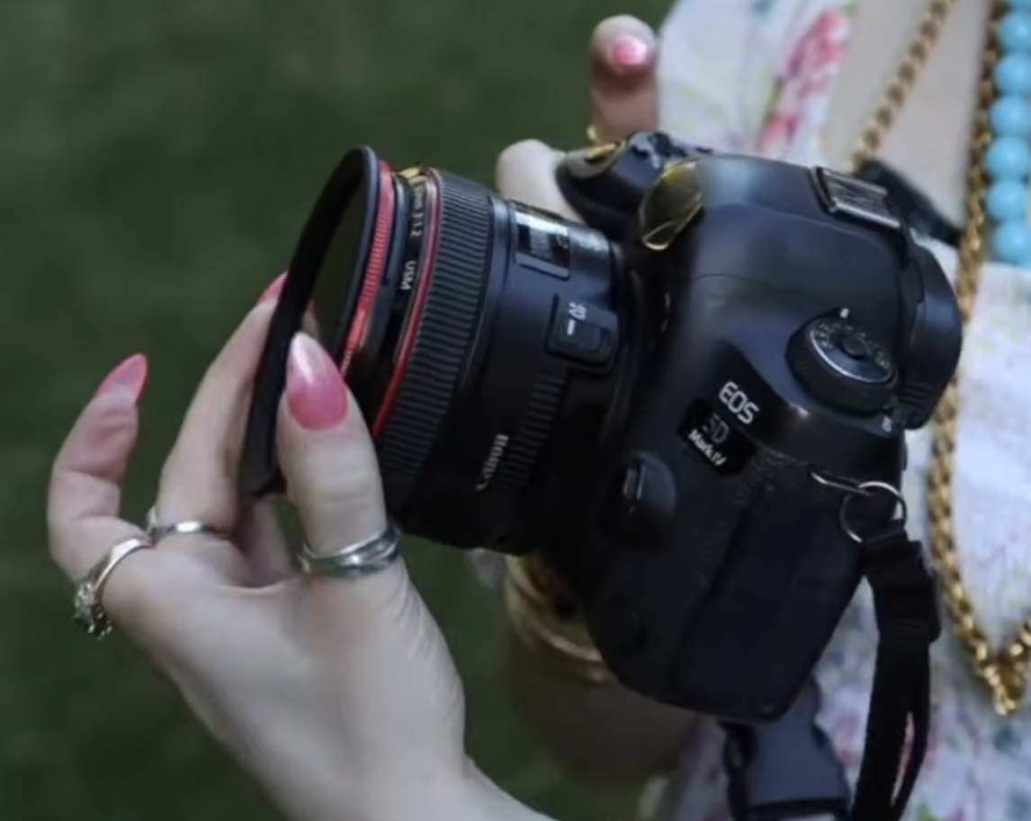 Side profile view of a variable ND filter attached to a camera lens, showing the adjustable ring used to control light stops for portrait photography.