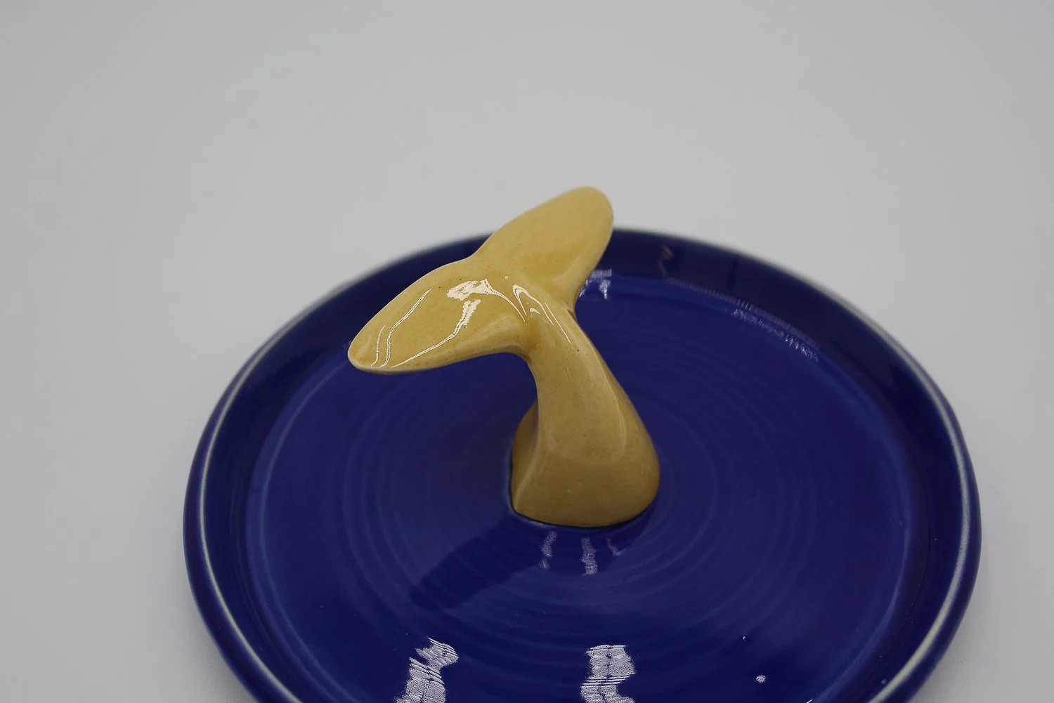Prato em cerâmica, com cauda cor de mel no centro, feito à mão na cor azul azulejo
