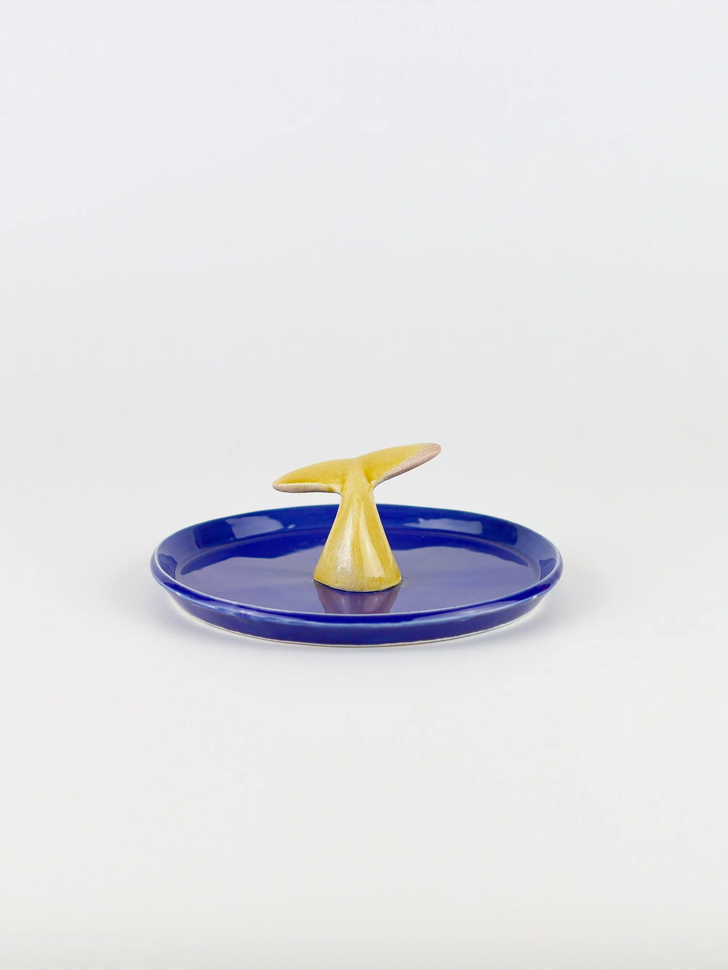Prato em cerâmica, com cauda cor de mel no centro, feito à mão na cor azul azulejo