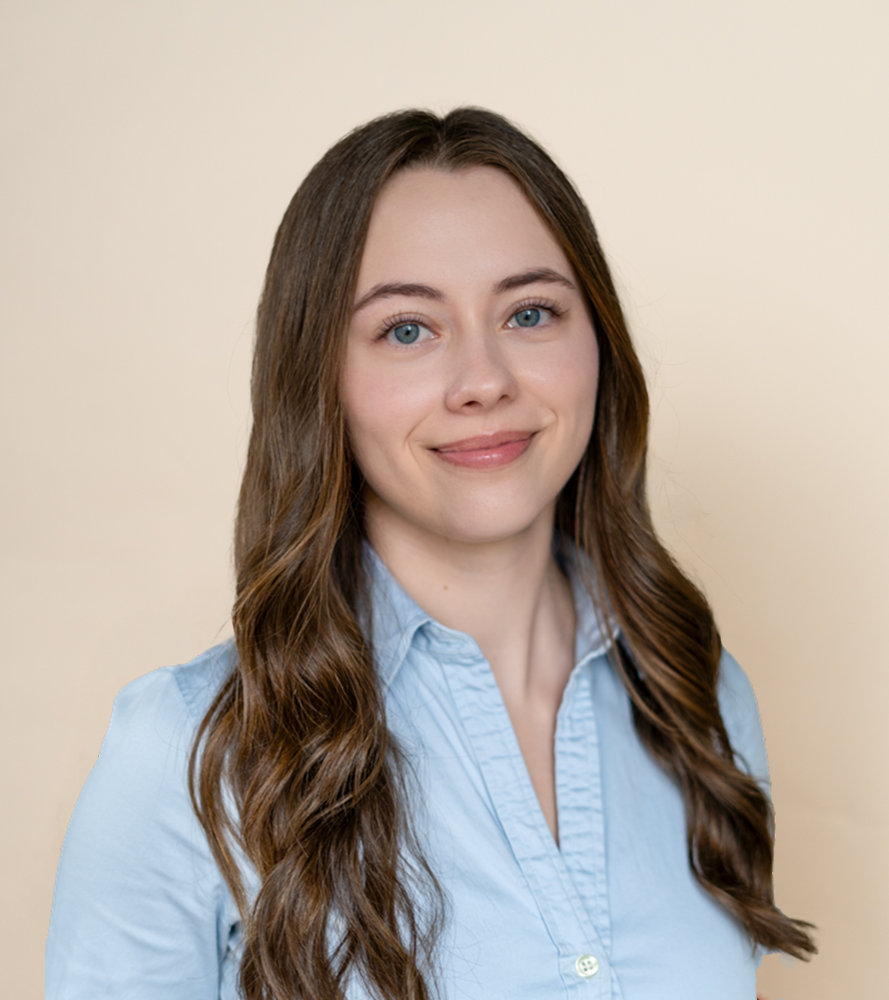 a young female with brown hear and blue eyes wearing a blue shirt