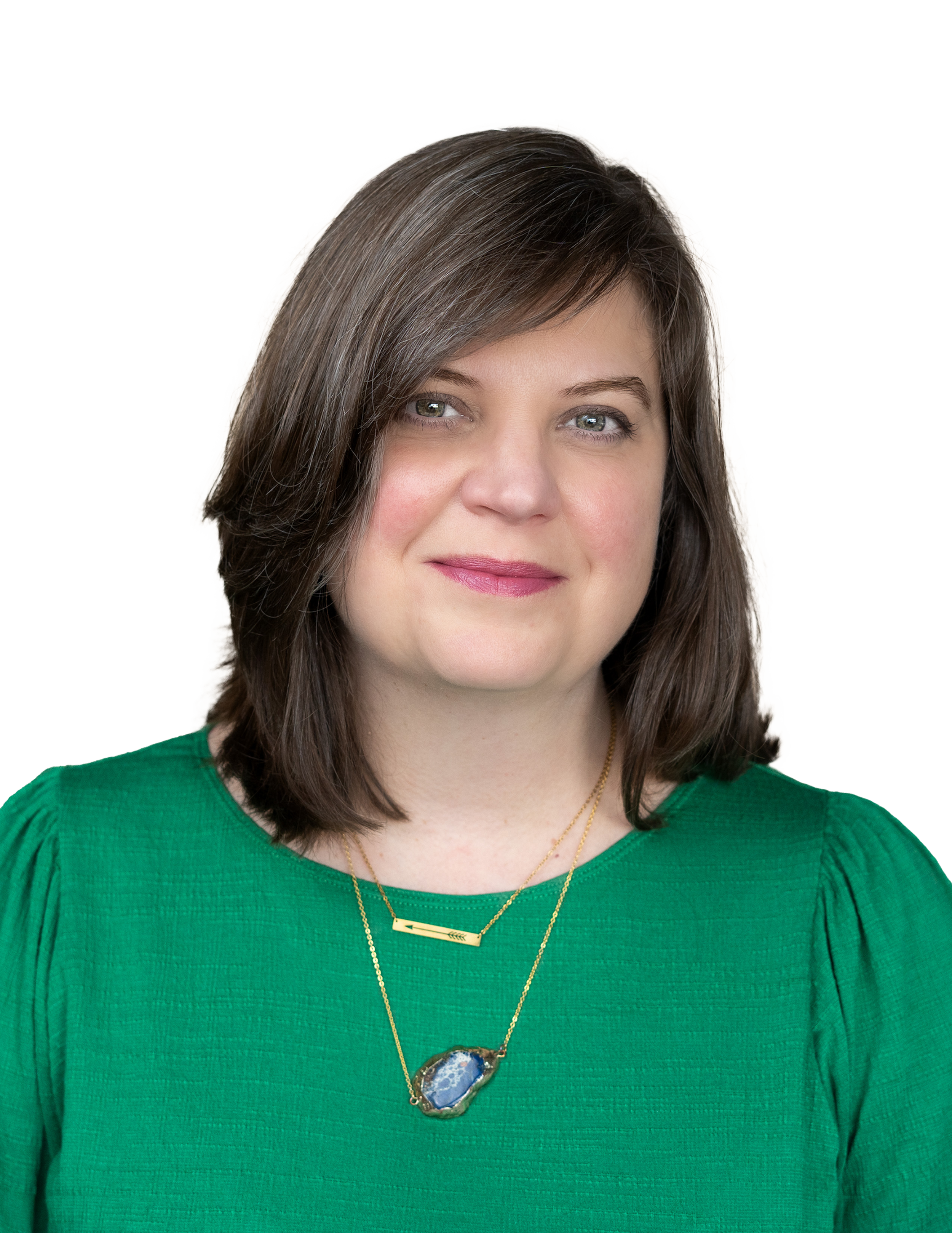 a headshot of a female with brown hair and green eyes wearing a green shirt with a crystal necklace