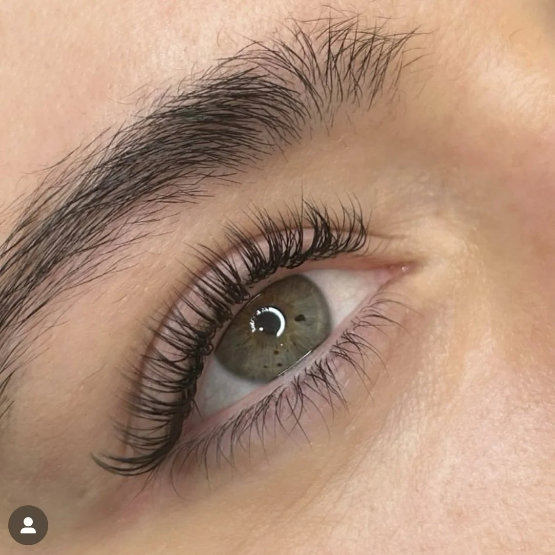 Close-up of an eye with long eyelashes and well-groomed eyebrow.