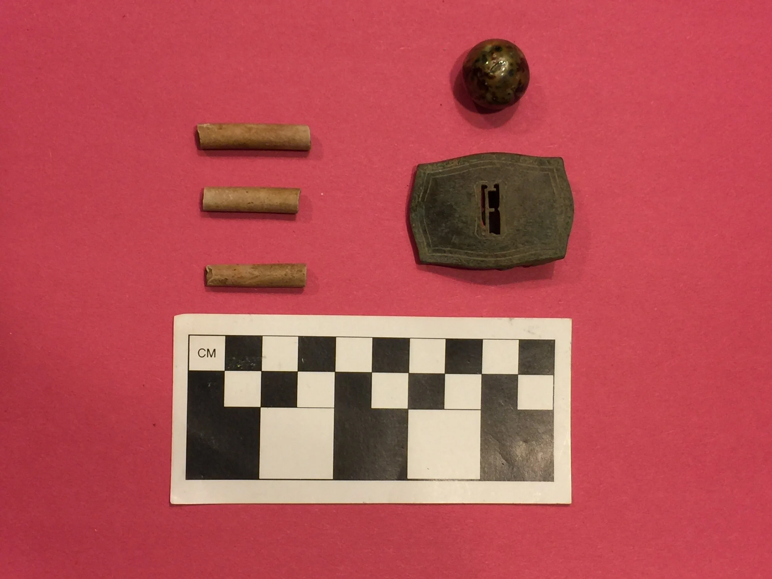 Clay tobacco pipe fragments, a glazed marble, and silver buckle recovered from the Concer site