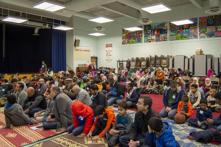 Families and children seated together for a program