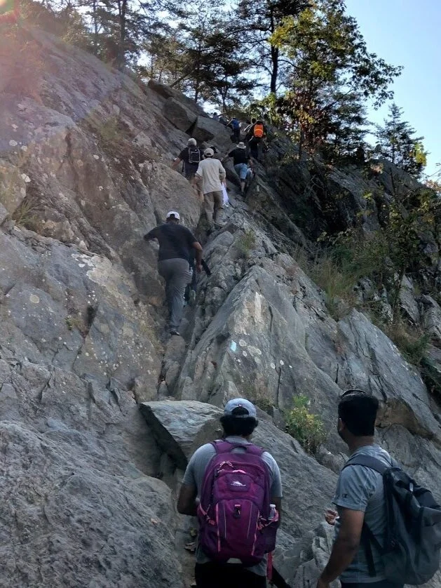 MFC members climbing rocks on a hiking trip at Great Falls