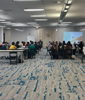 Guests at tables facing a presentation screen