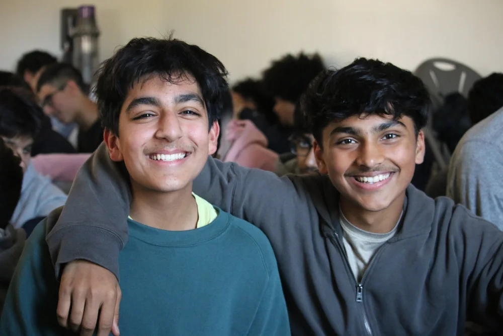 Two young brothers smiling at an MFC youth gathering