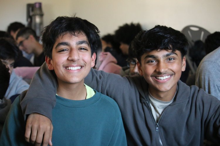 Two young brothers smiling at an MFC youth program