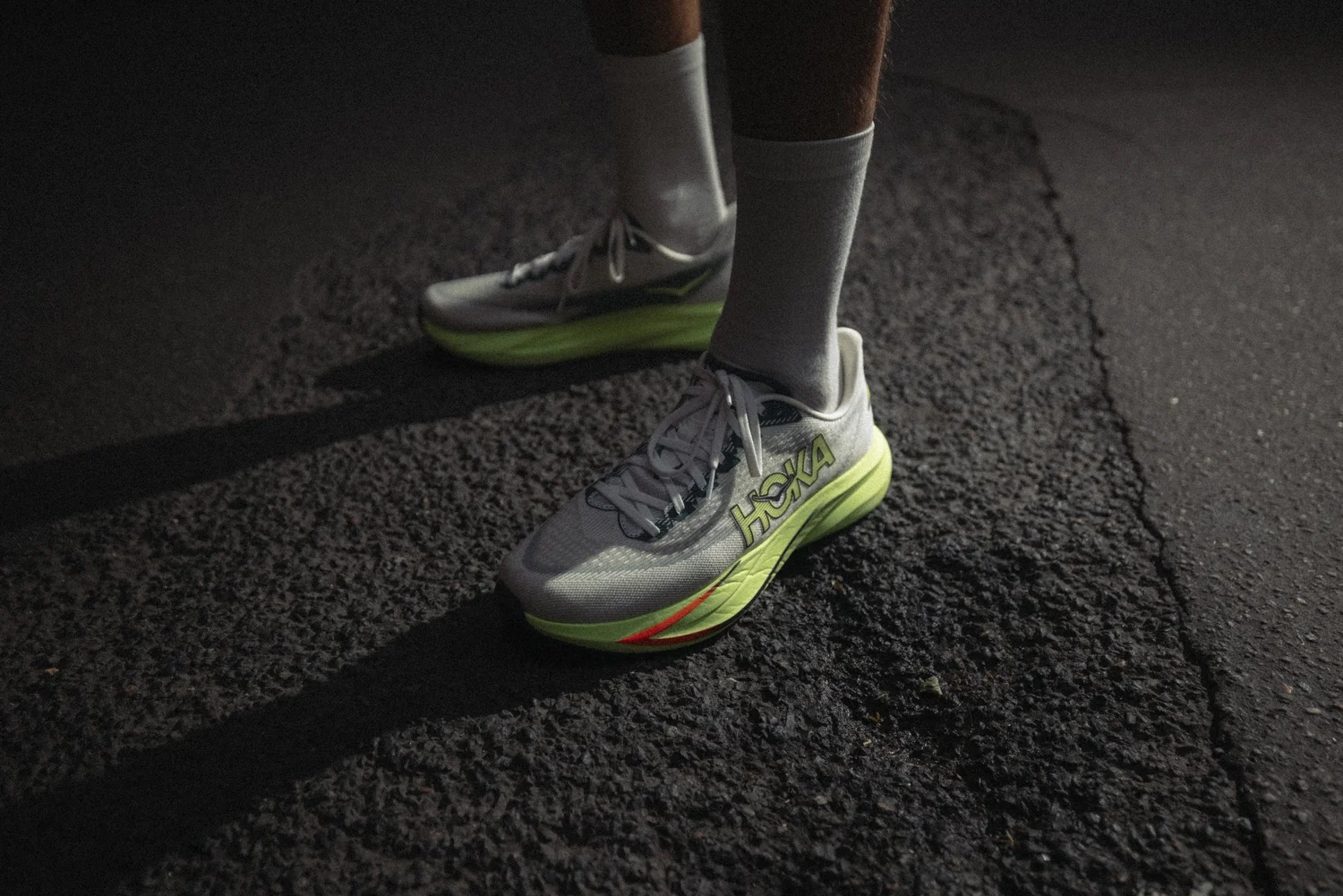 Chaussure HOKA Mach 7 posée sur l'asphalte, photographie produit pour une campagne de lancement