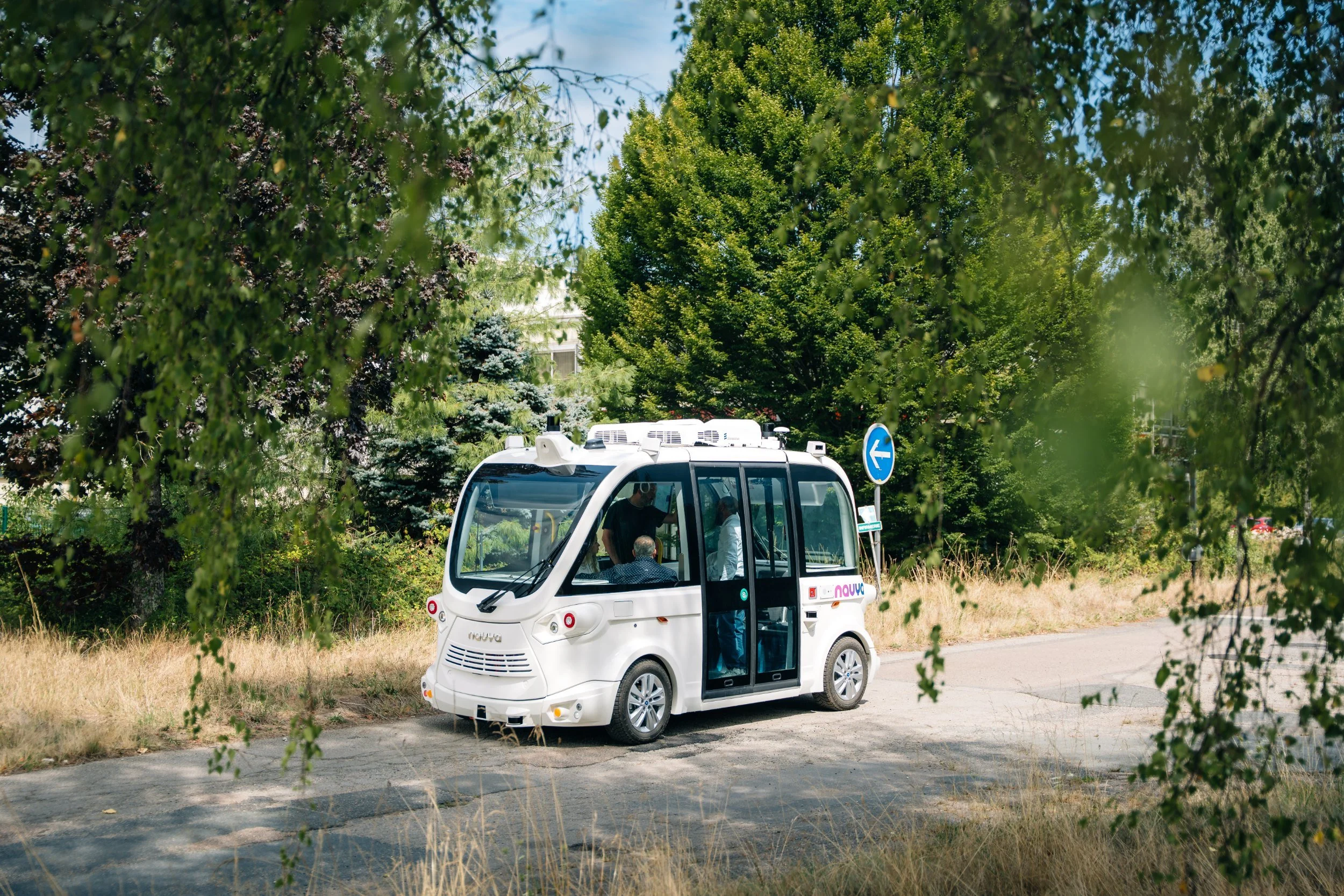 Navette autonome Navya Mobility sur une route arborée, photo de campagne LUSANT Prod.