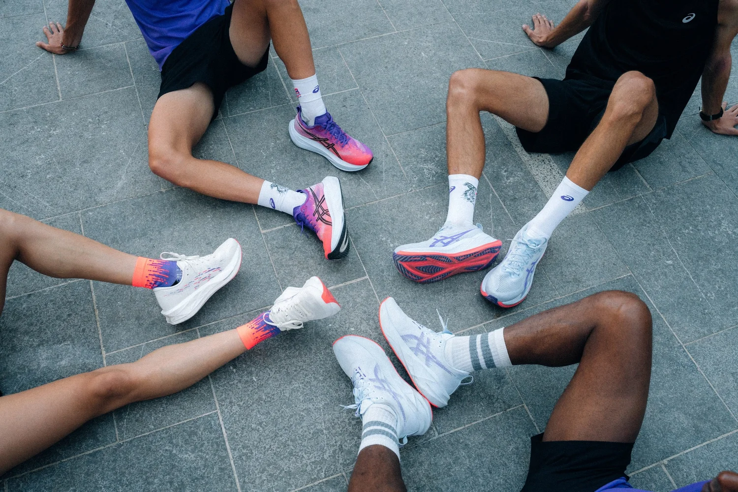 Chaussures ASICS de la collection Tokyo portées par un groupe de coureurs assis en cercle, film de campagne