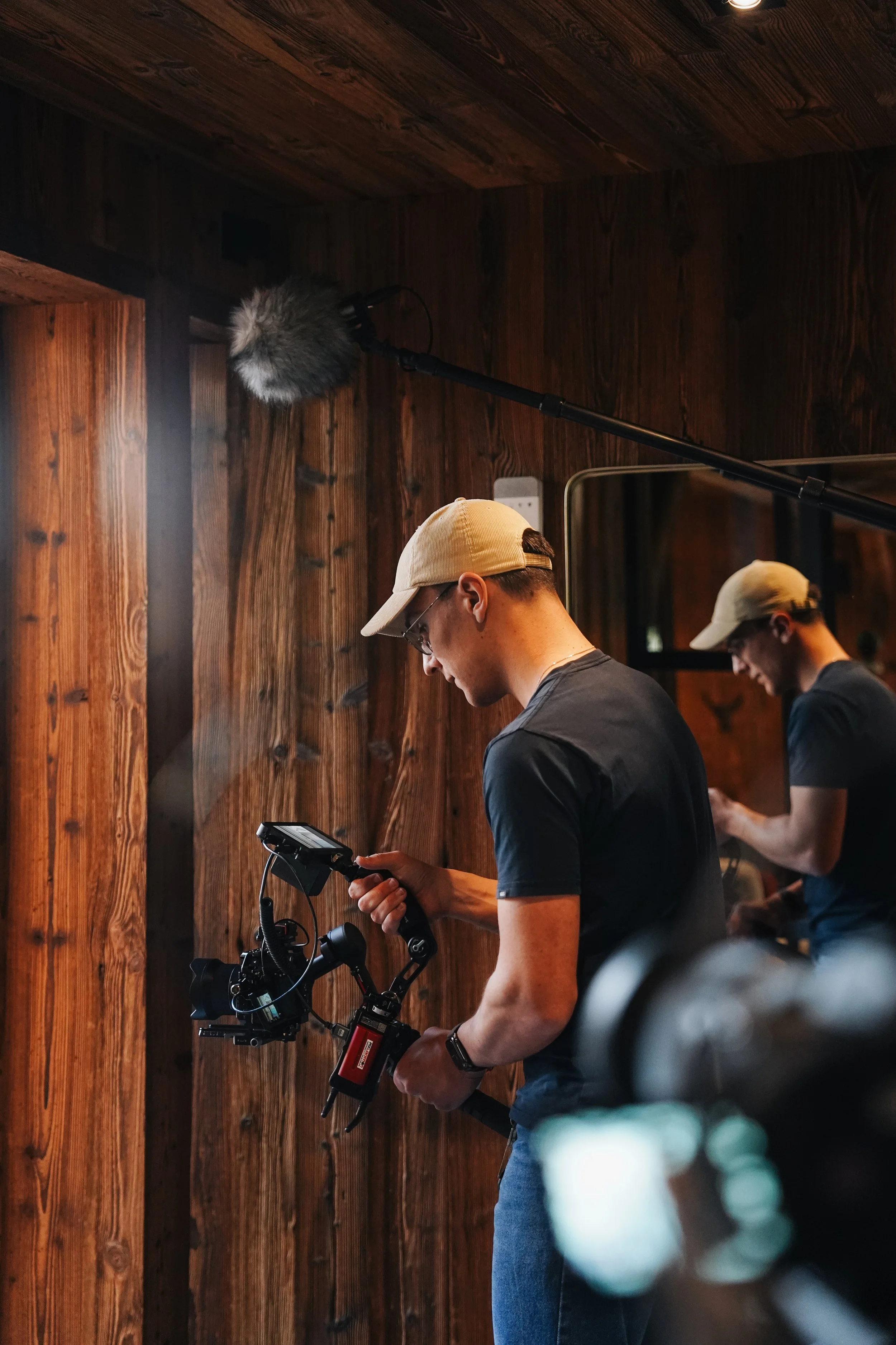 Cadreur filmant au stabilisateur dans un chalet en bois, coulisses du tournage Résidentiae