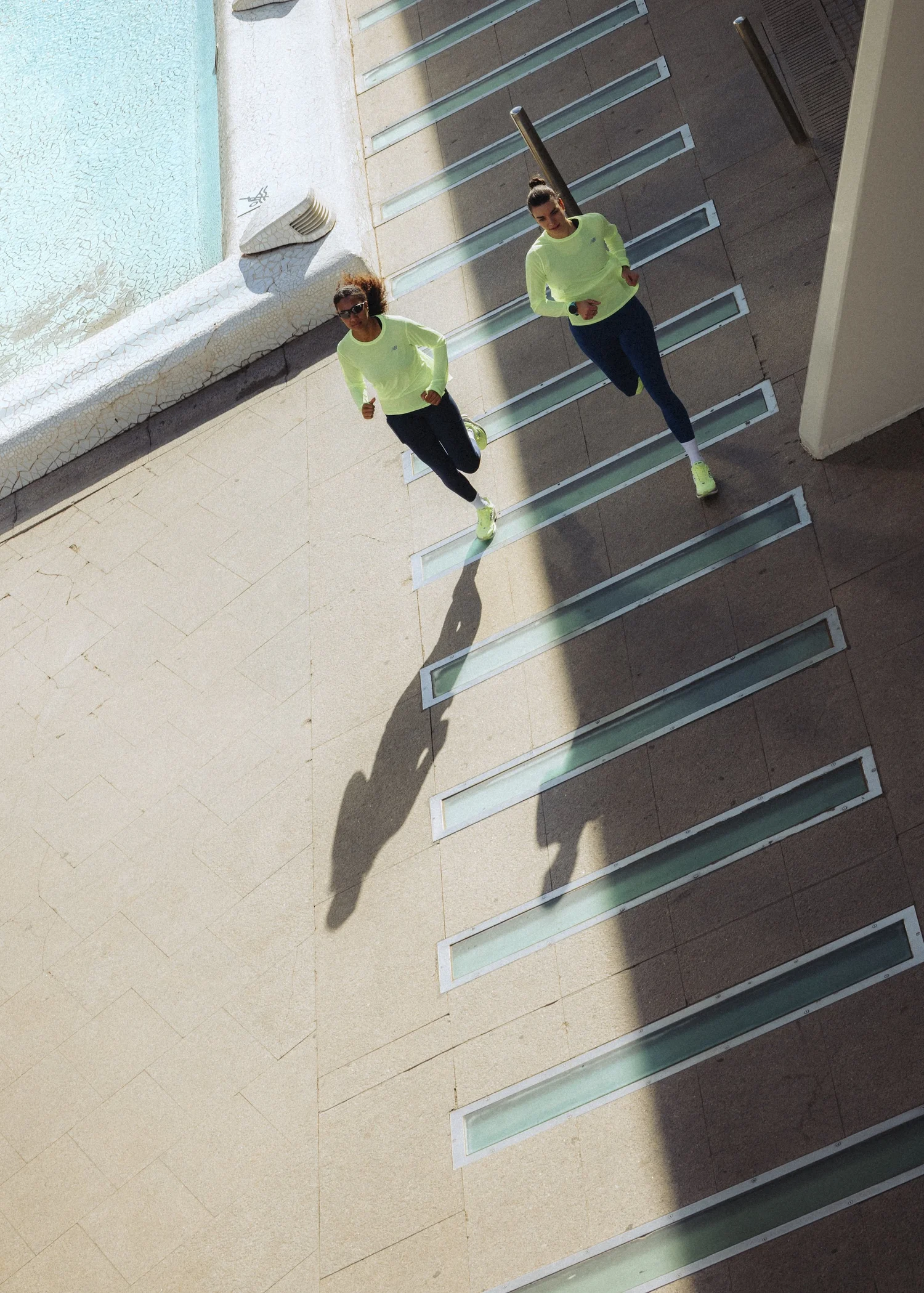 Deux coureuses New Balance vues d'en haut sur un escalier de béton à Valence, campagne de marathon