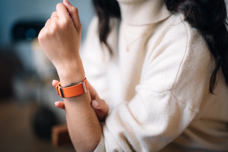 Bracelet connecté orange porté au poignet, campagne produit Modelabs