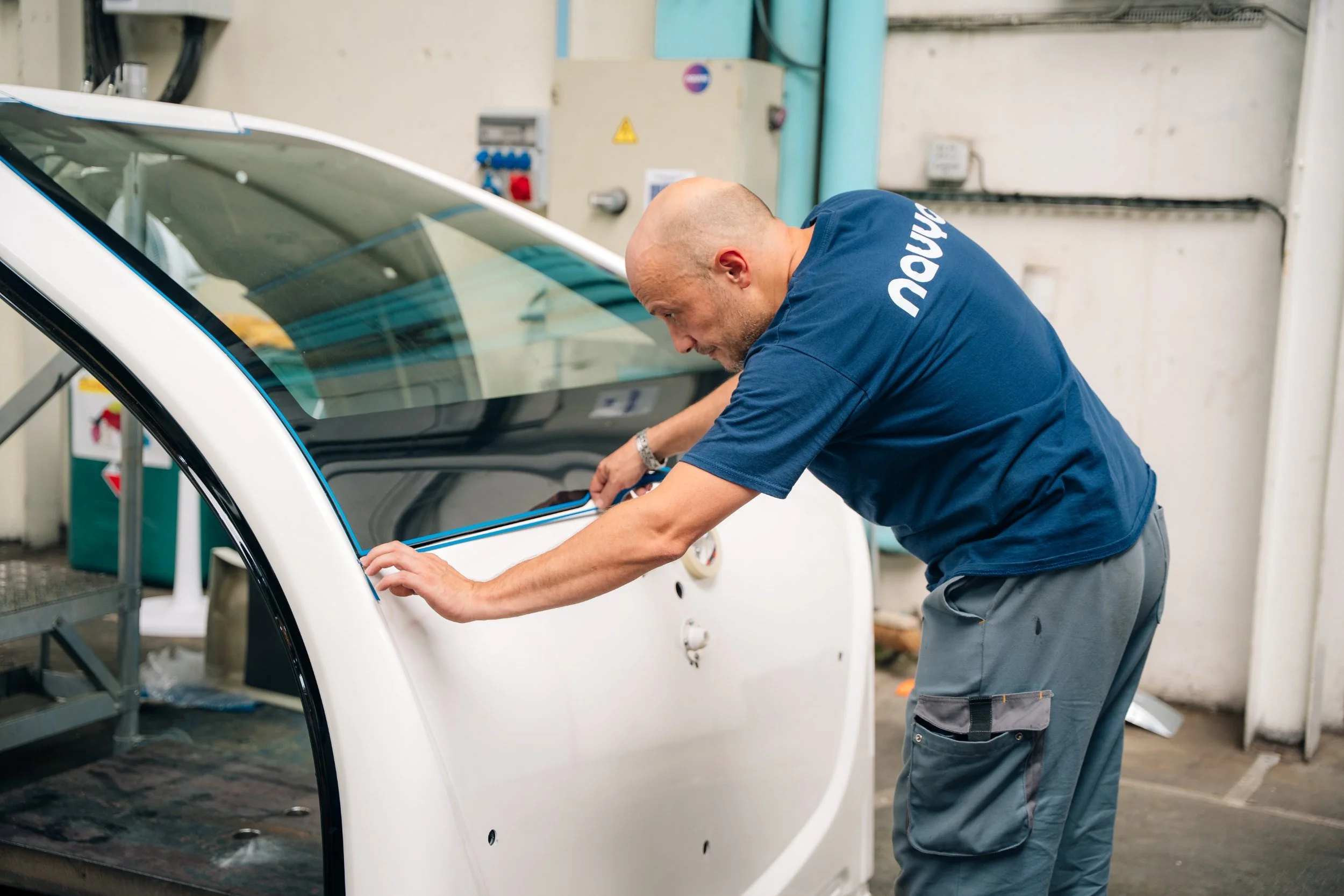 Technicien Navya Mobility contrôlant une porte de navette dans l'usine de Vénissieux
