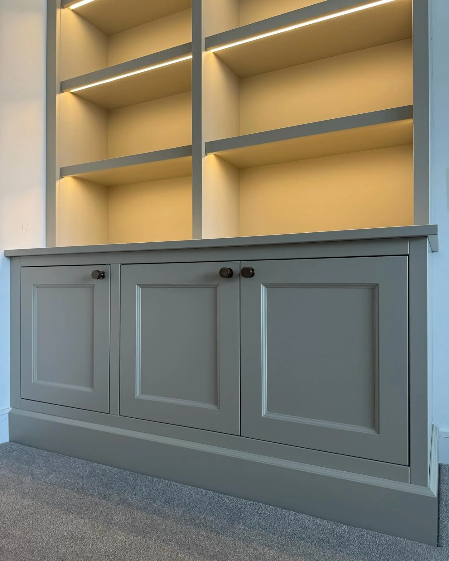 Beautifully framing the doorway, these bespoke bookcases bring balance and storage without overpowering the room.

Designed alongside a media unit within the same space, the pieces share detailing, colour, and hardware, giving the room a consistent f