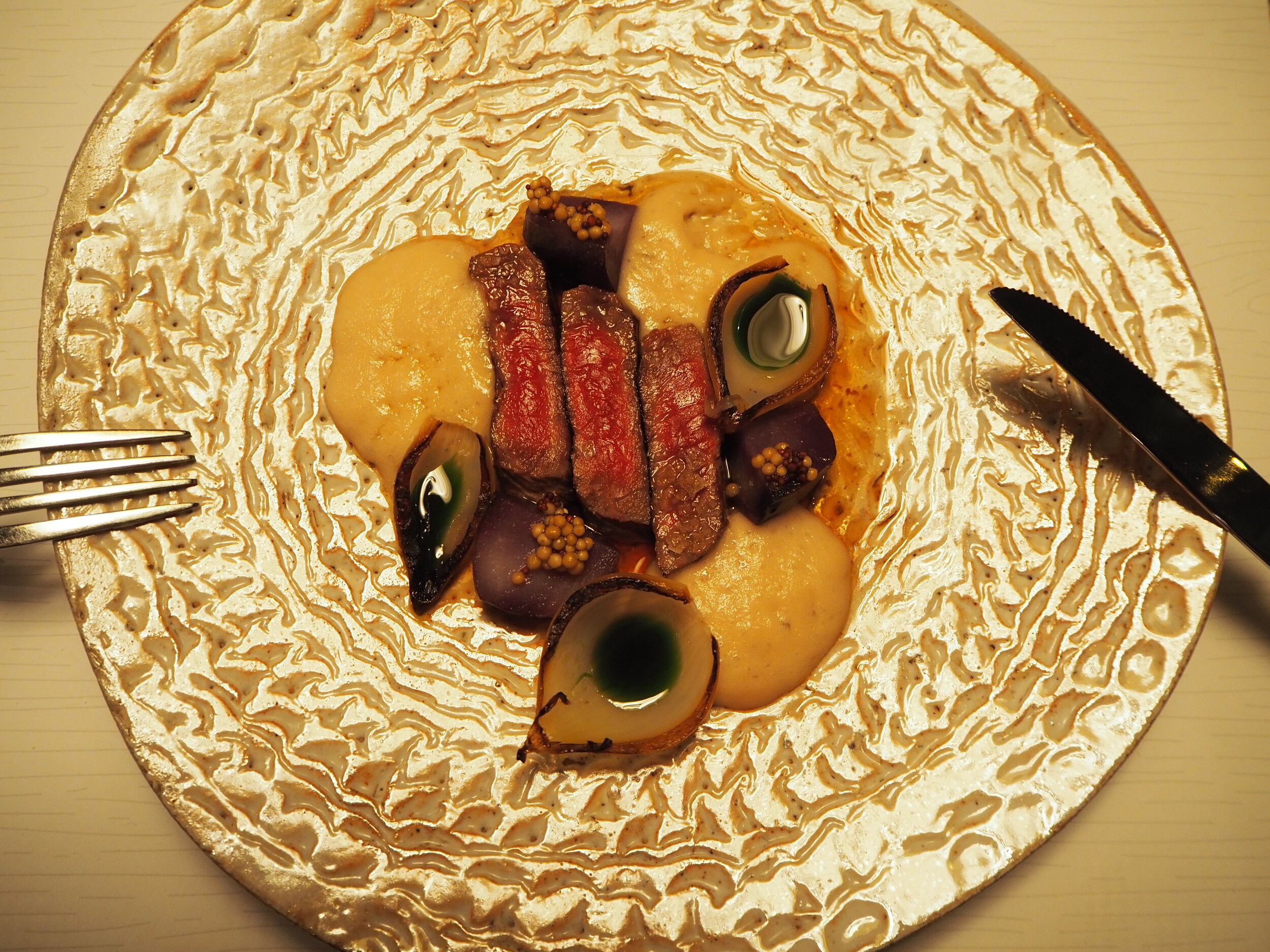 steak, caramelized onion foam, roasted onion with herb oil, purple potato